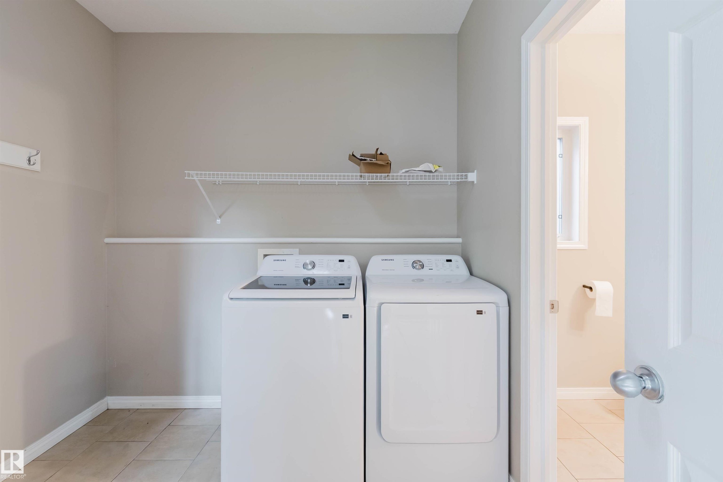 Laundry area with tile flooring and a wall-mounted wire shelf - 11608 96 Street Nw, Edmonton, AB