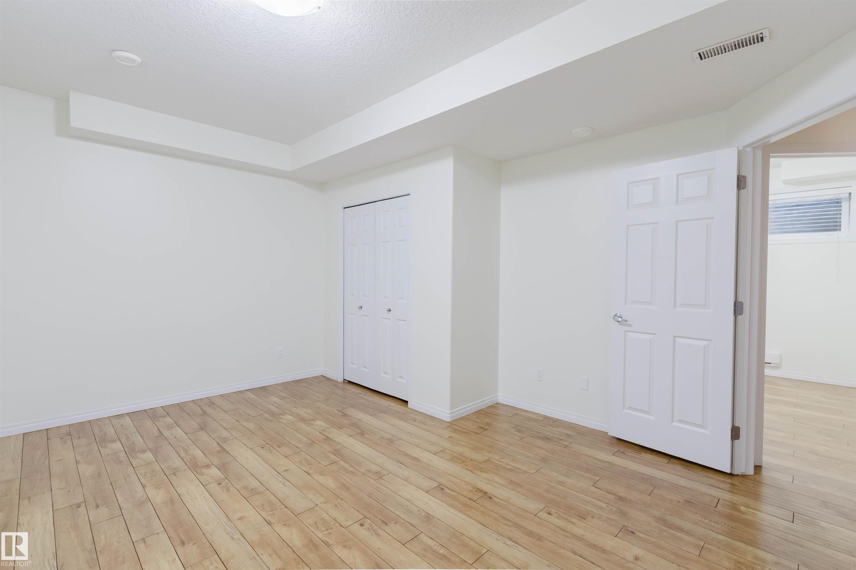 Wood-finish flooring, bi-fold closet doors, and recessed ceiling lighting - 11608 96 Street Nw, Edmonton, AB
