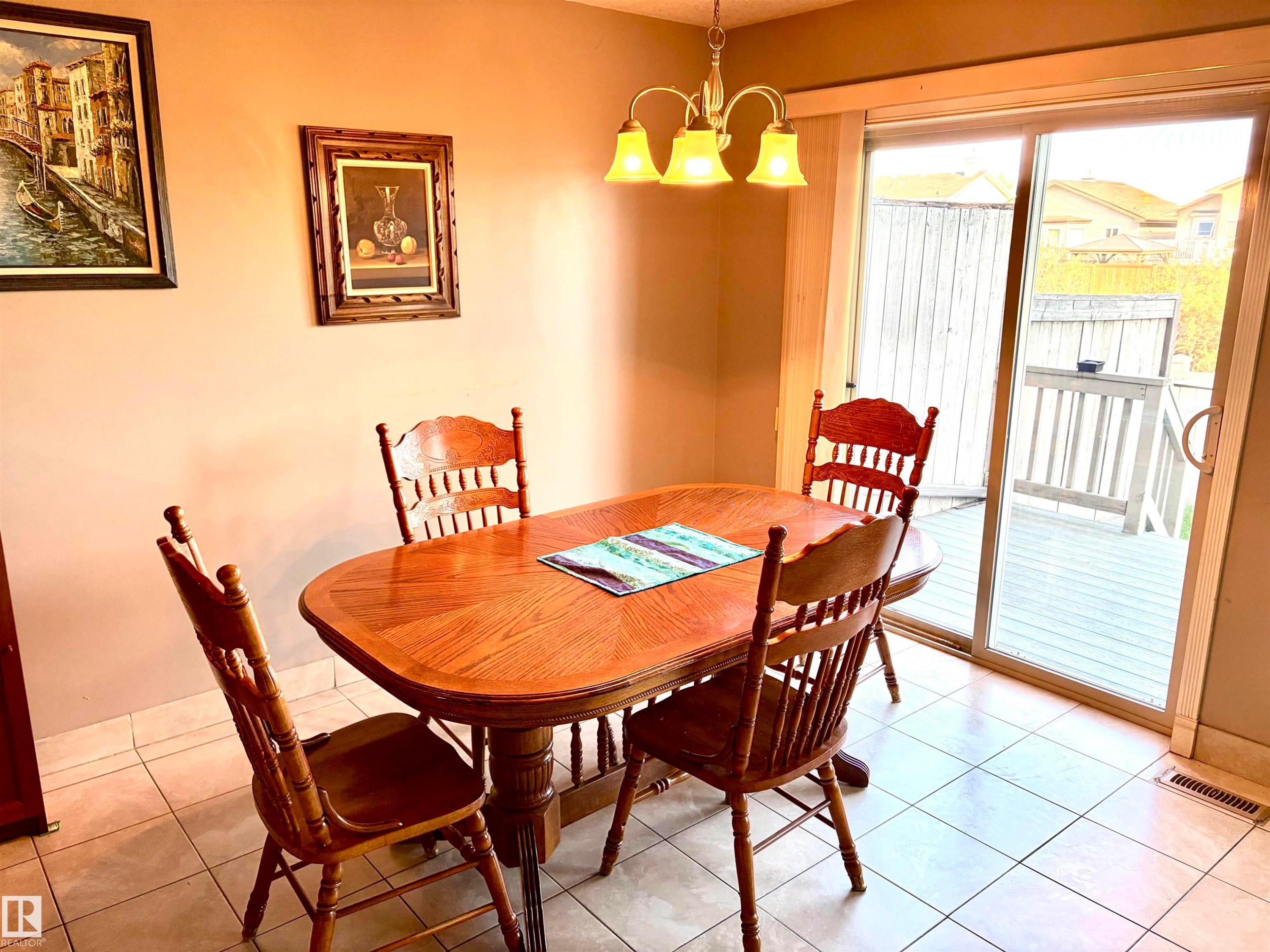 Tile flooring, sliding glass door, overhead chandelier, outdoor decking, wooden railing - #17 16317 64 St Nw, Edmonton, AB