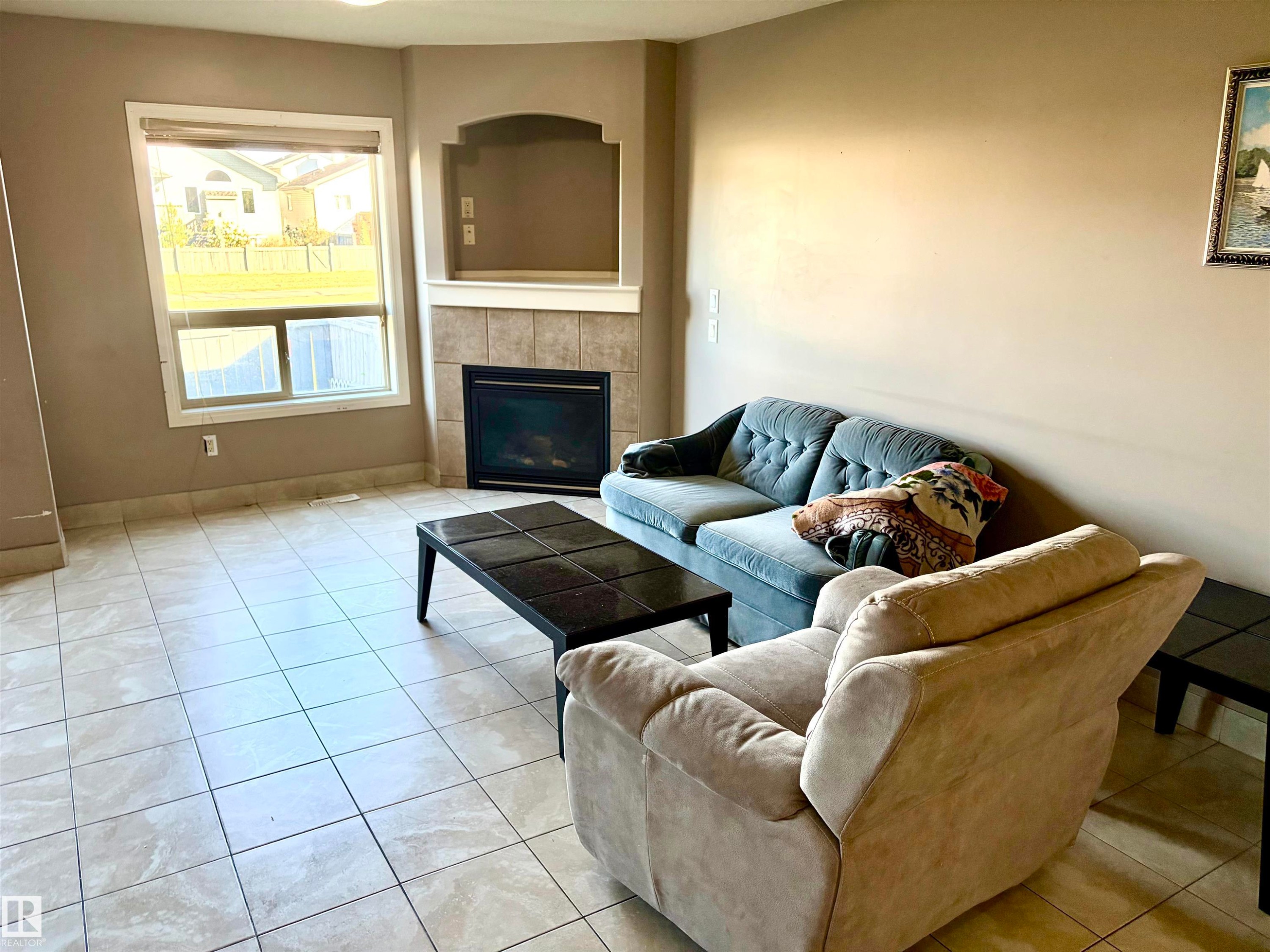 Corner fireplace with a tile surround and mantel - #17 16317 64 St Nw, Edmonton, AB