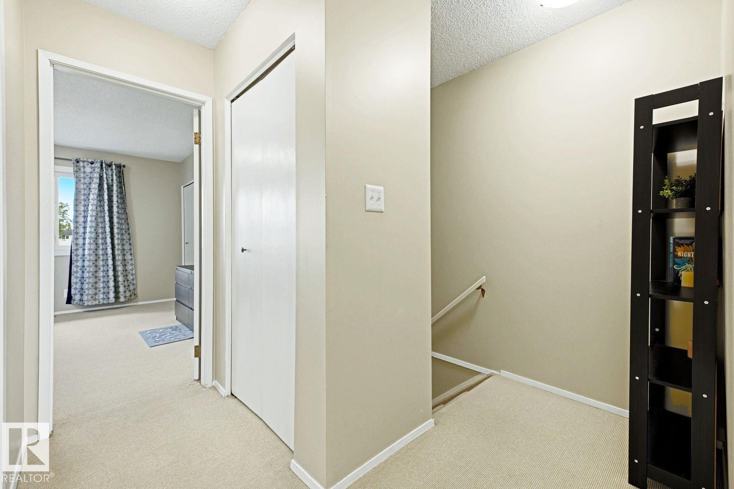 Neutral wall paint, carpeted flooring, built-in closet, and an interior window with natural light - 11317 22 Avenue Nw, Edmonton, AB