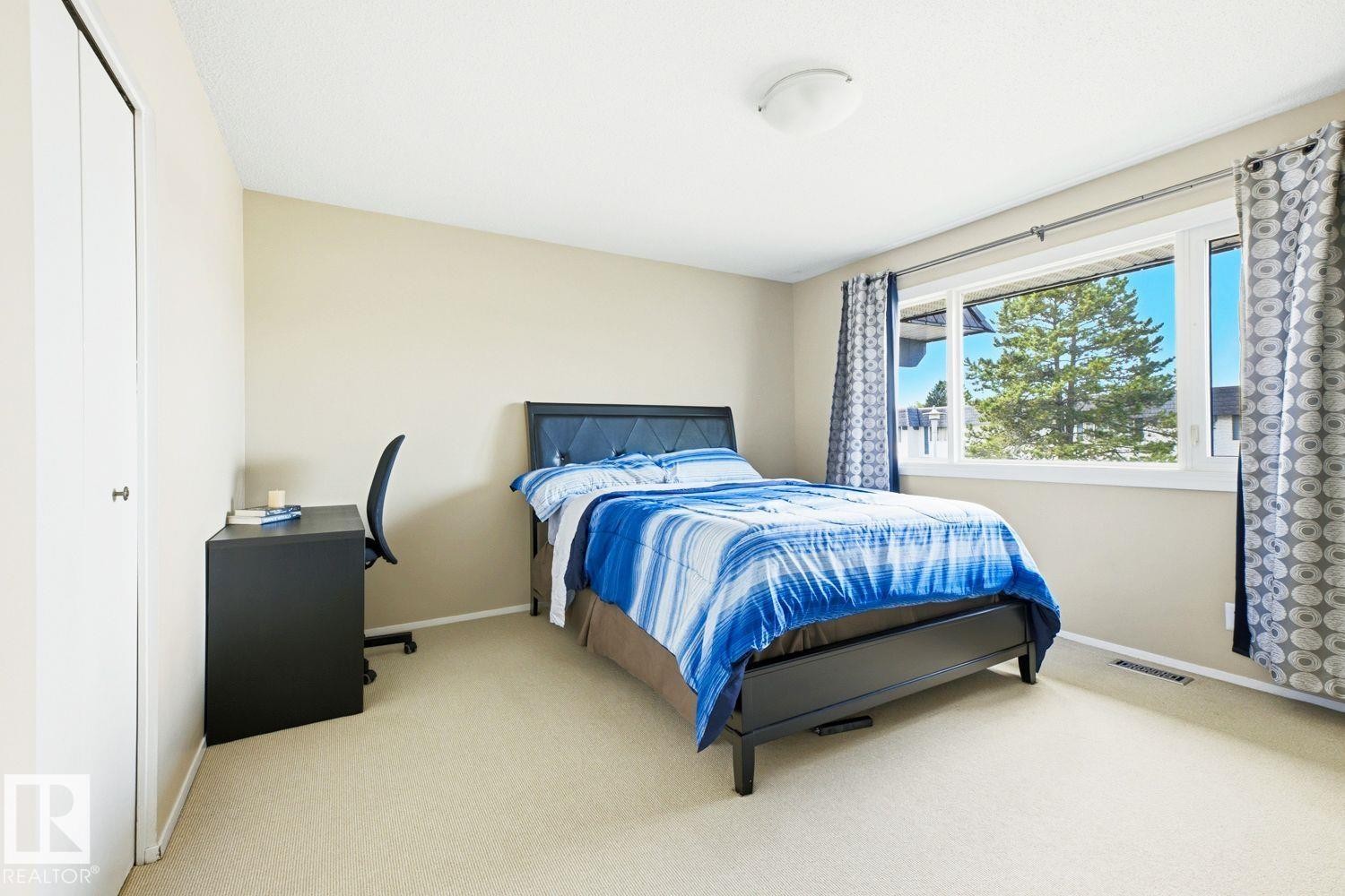 Bedroom featuring a large window, neutral wall paint, and ceiling-mounted light fixture - 11317 22 Avenue Nw, Edmonton, AB