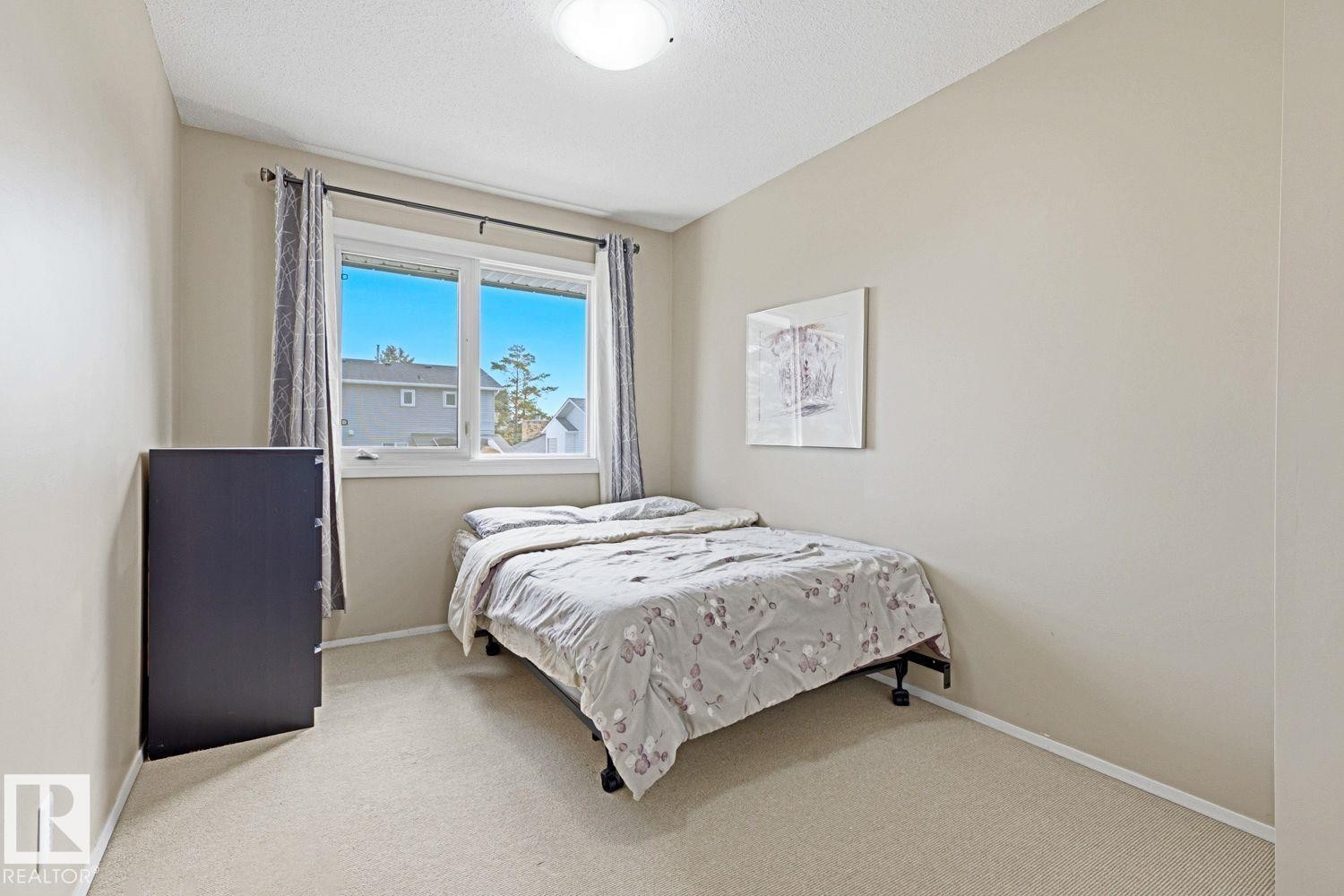 Neutral-toned walls complement the window with a dark rod - 11317 22 Avenue Nw, Edmonton, AB