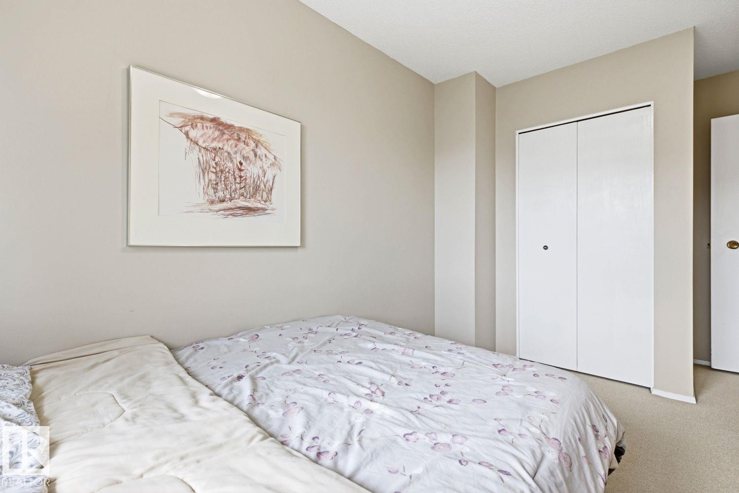 Neutral-toned walls with carpet flooring, featuring a white bi-fold closet door - 11317 22 Avenue Nw, Edmonton, AB