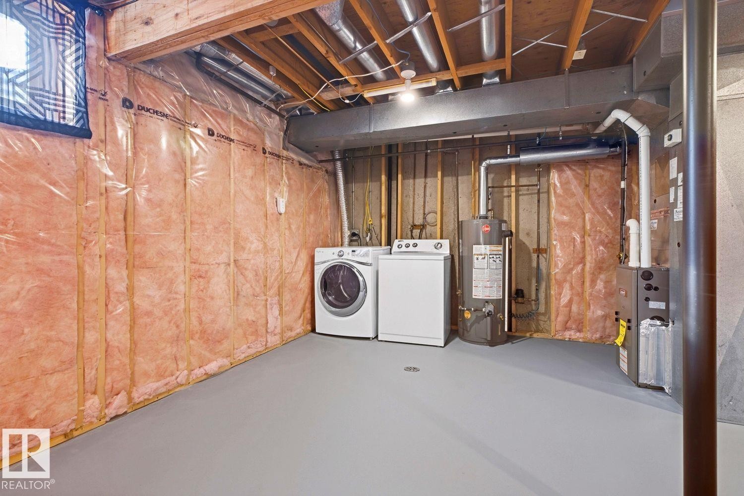 Unfinished basement with exposed ceiling joists, insulation, and painted concrete flooring - 11317 22 Avenue Nw, Edmonton, AB