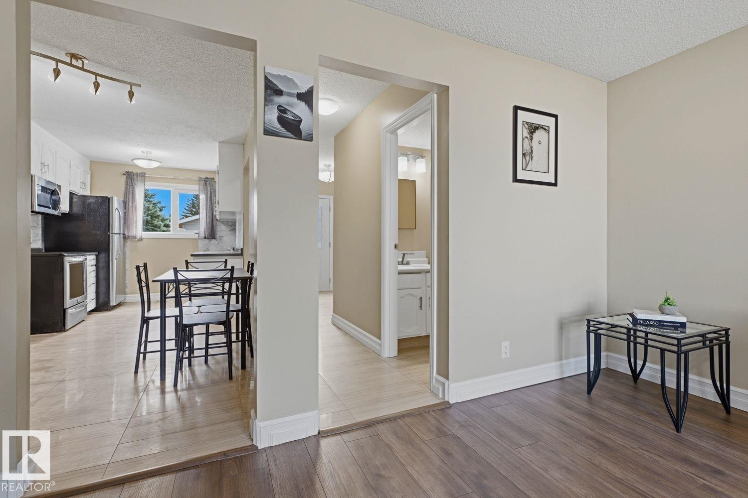 Wood-finish flooring throughout the main area and tile flooring in the kitchen and hallway - 11317 22 Avenue Nw, Edmonton, AB