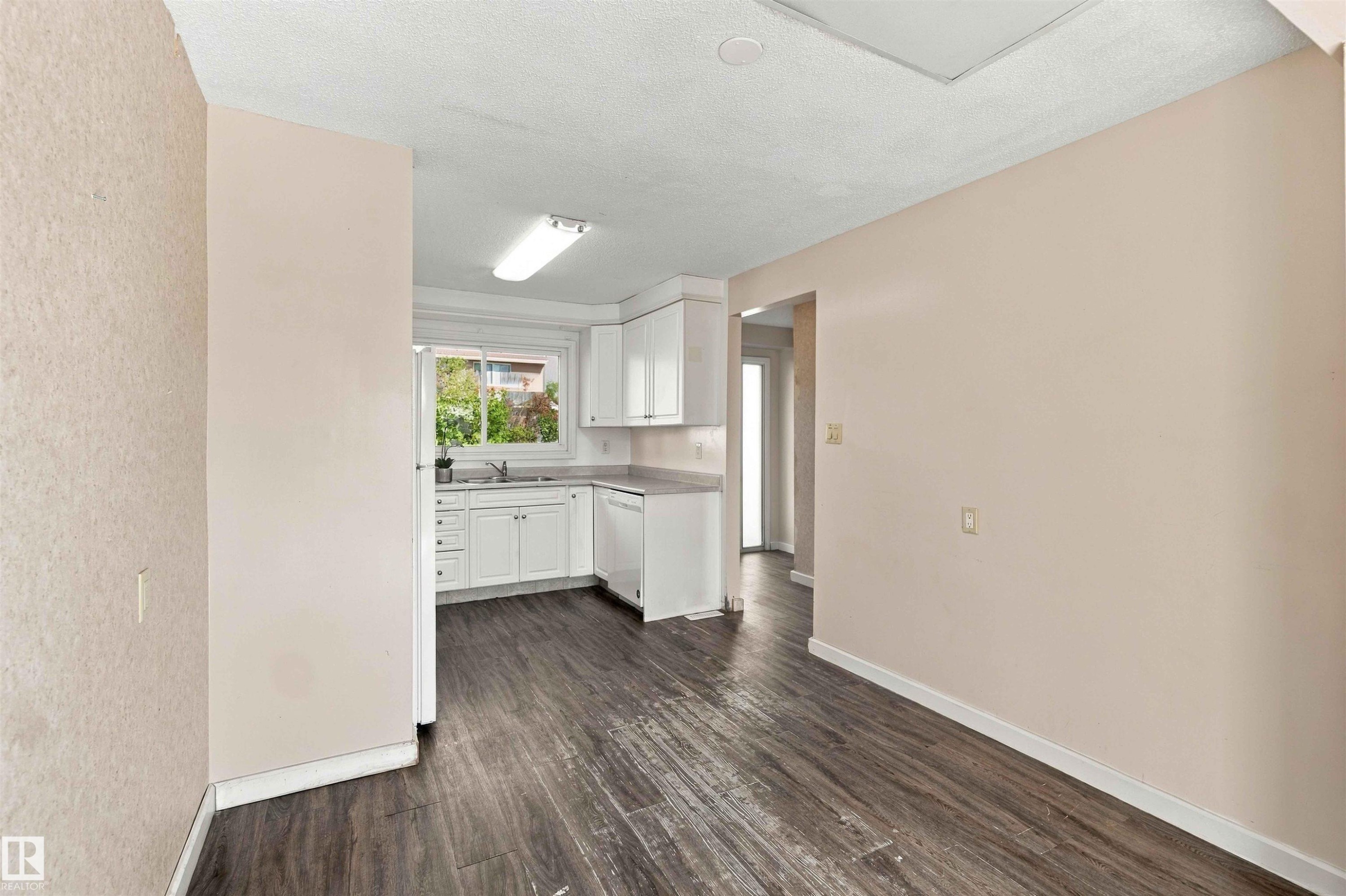 Kitchen featuring white cabinetry, a sink, and dark wood-finish flooring - 17351 85 Avenue Nw, Edmonton, AB