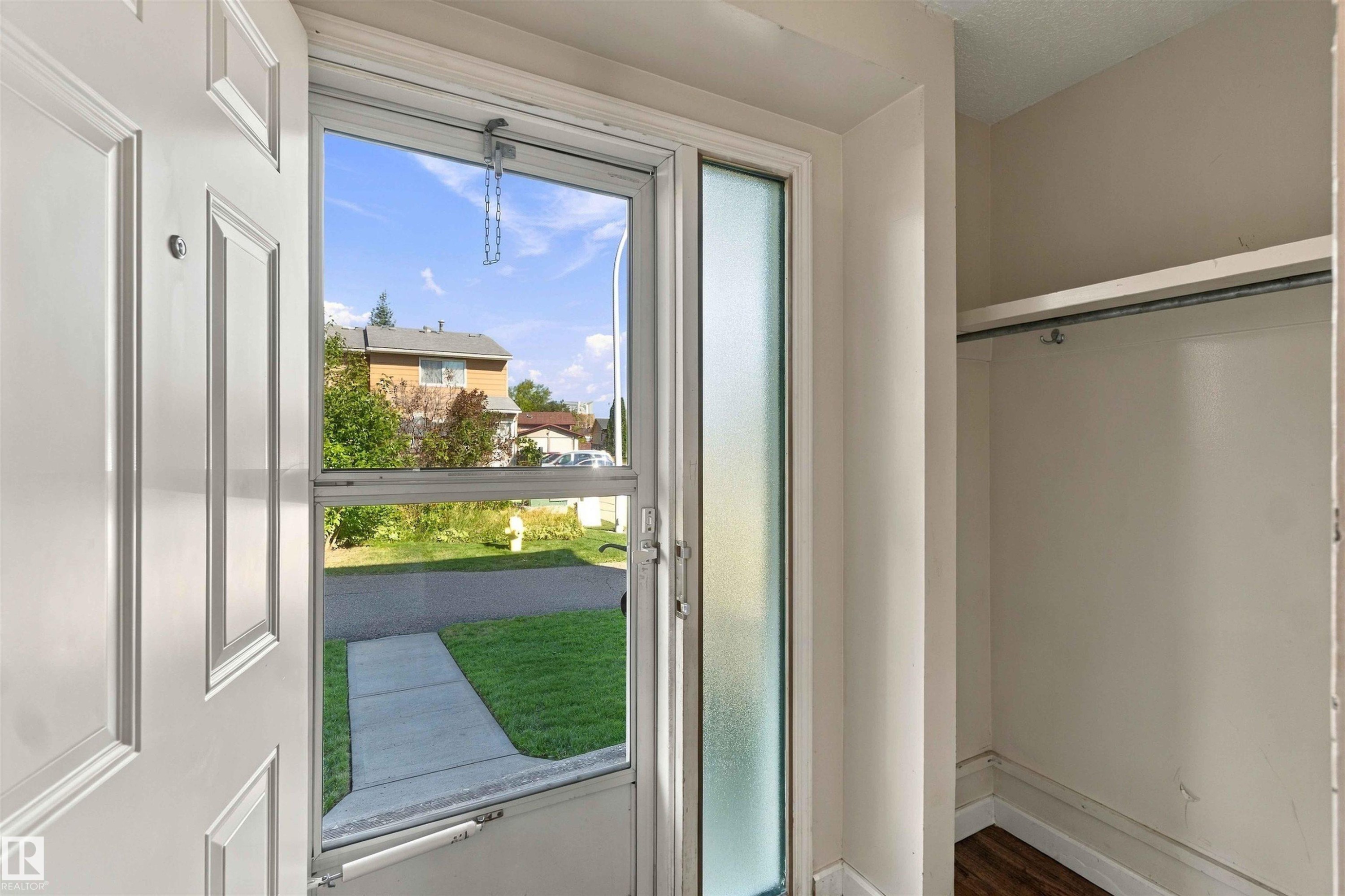 Entryway featuring a paneled door, screen door with clear glass, and a frosted sidelight - 17351 85 Avenue Nw, Edmonton, AB