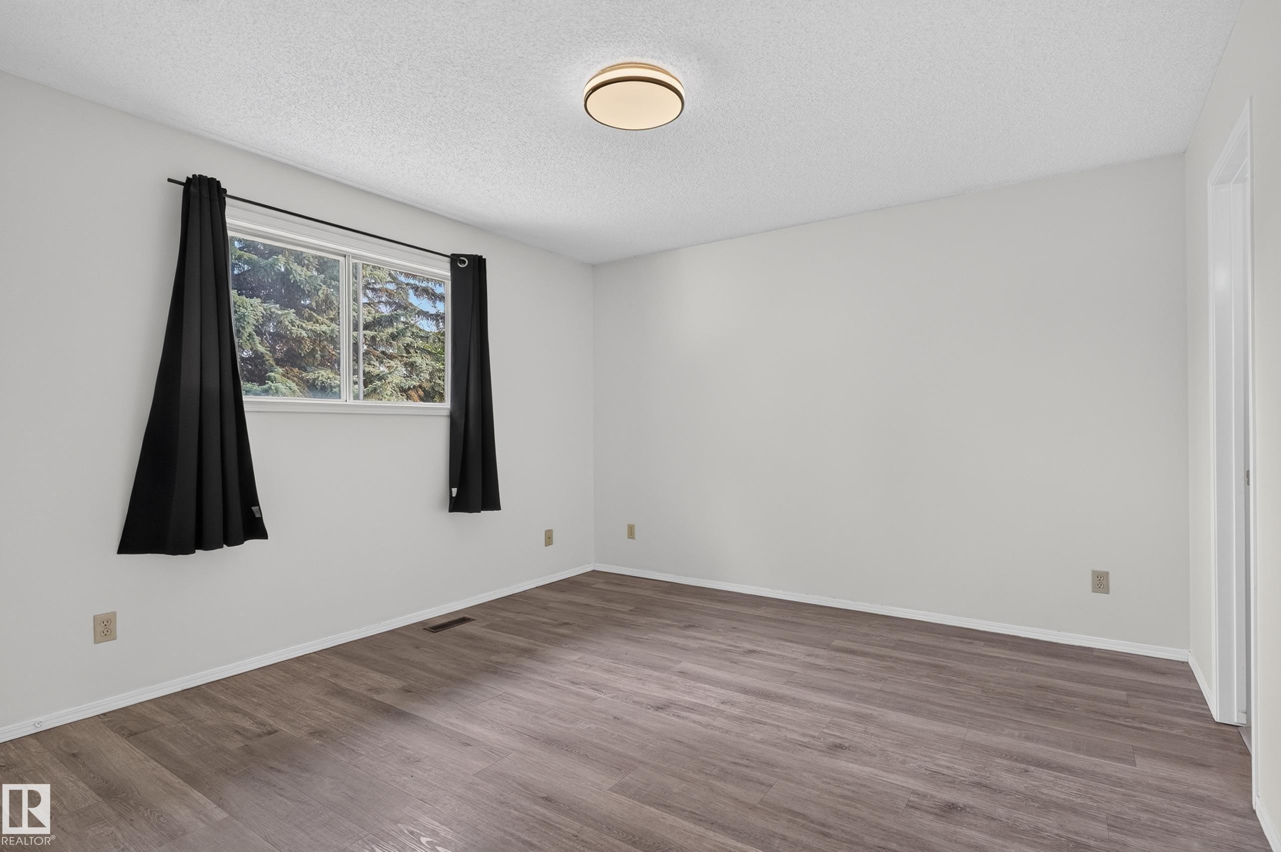 Wood-finish flooring, white walls, and a contemporary ceiling light fixture - 3722 34A Avenue Nw, Edmonton, AB