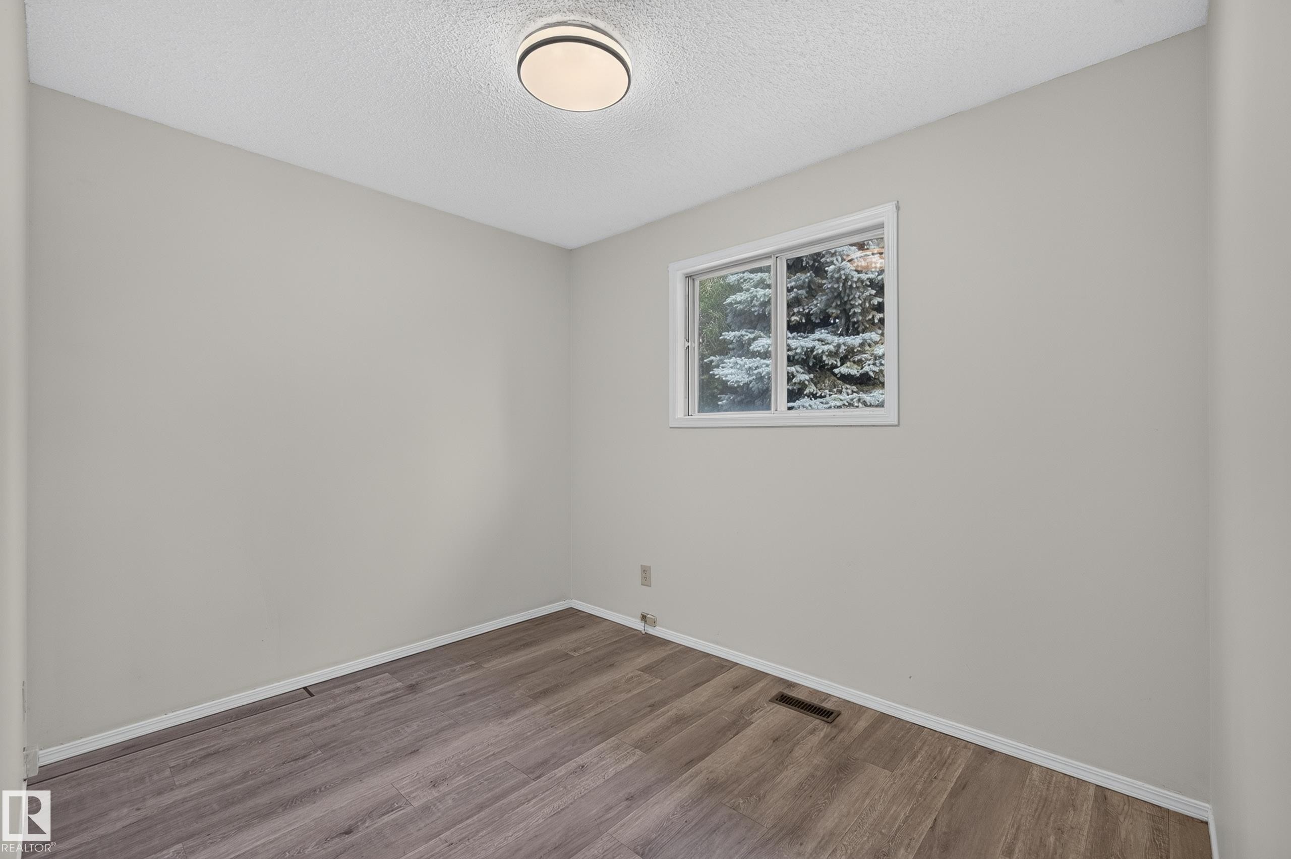 Neutral wall color, wood-finish flooring, white trim, and flush mount lighting - 3722 34A Avenue Nw, Edmonton, AB