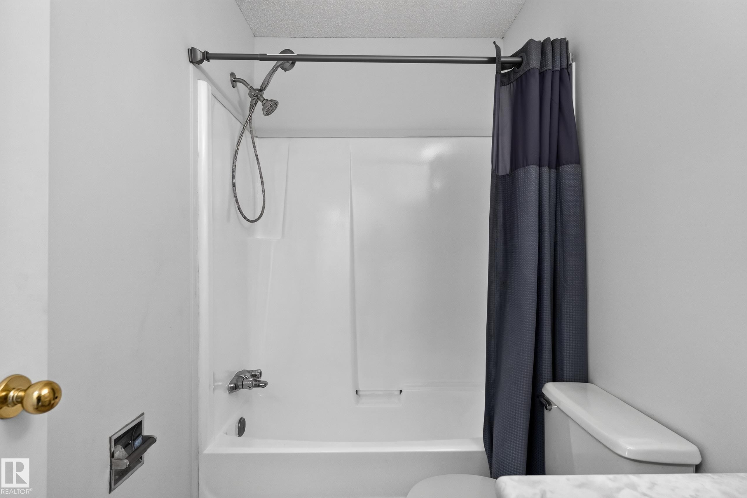 White tub/shower combination with a chrome shower head and faucet - 3722 34A Avenue Nw, Edmonton, AB