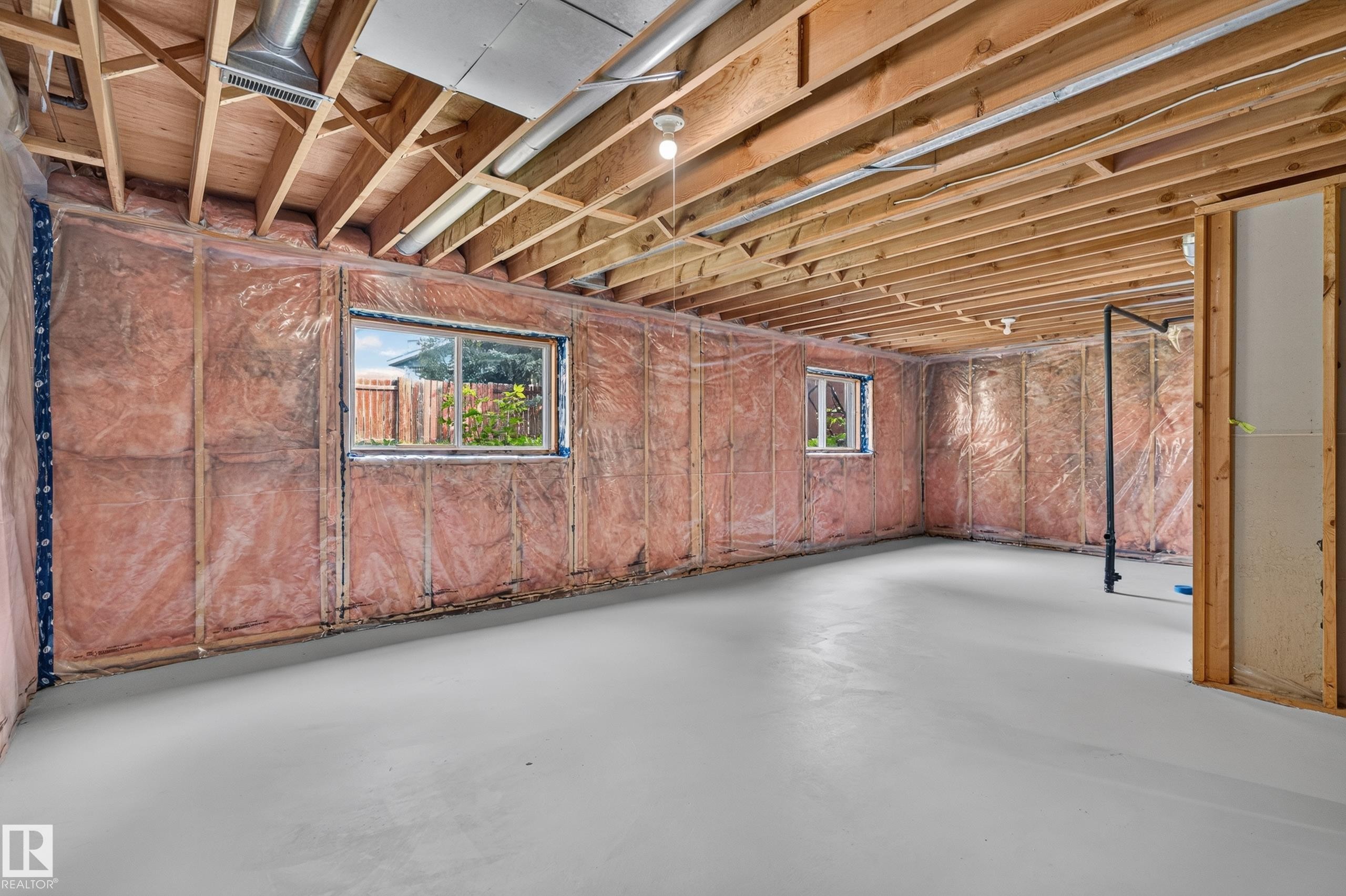Unfinished basement space featuring exposed wood joists, insulated walls, two windows, and a concrete floor - 3722 34A Avenue Nw, Edmonton, AB