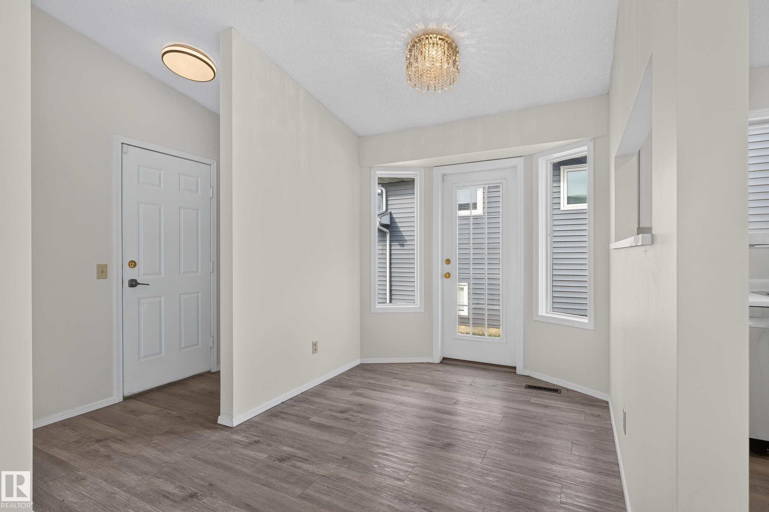 Wood-finish flooring, bay window with multiple panes, and a glass-paneled exterior door - 3722 34A Avenue Nw, Edmonton, AB