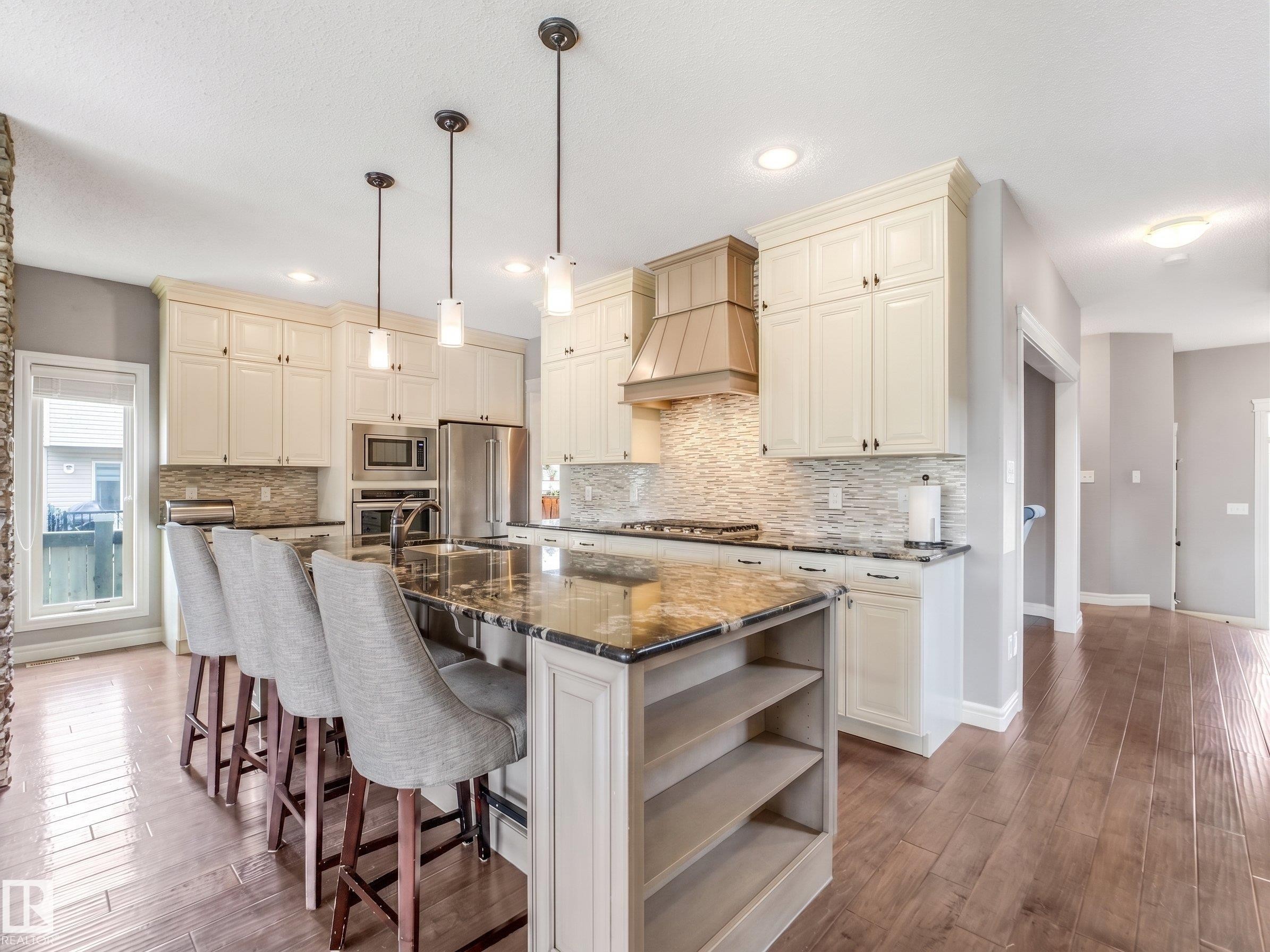 A beautifully upgraded home featuring premium appliances and finishes, including a sleek built-in countertop gas stove and upgraded hood fan - all thoughtfully chosen to maximize comfort and safety. - 3711 Westcliff Way Sw, Edmonton, AB