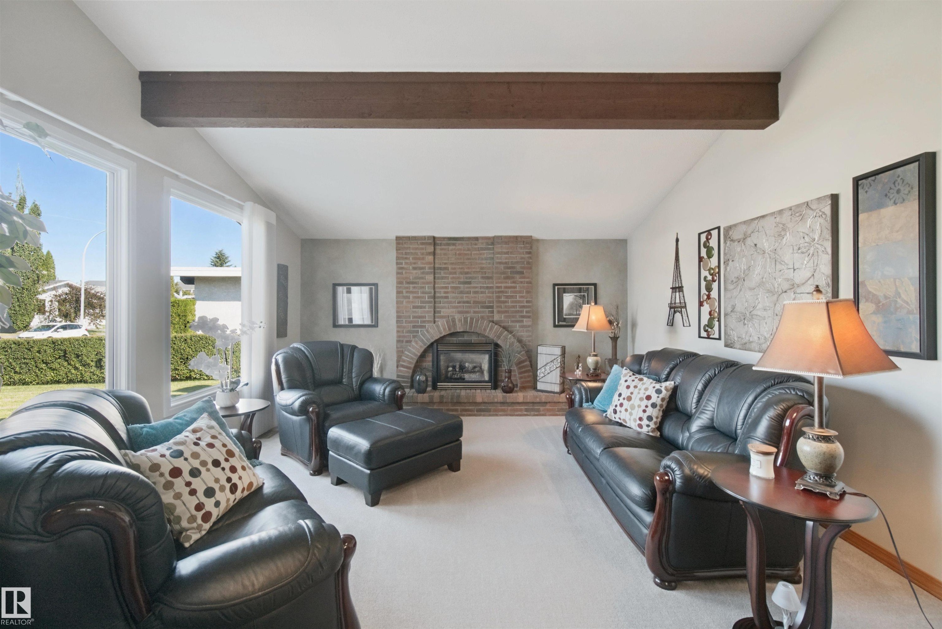 Vaulted ceilings with exposed wood beams, a brick facing gas fireplace and large windows - 11439 144 Avenue Nw, Edmonton, AB