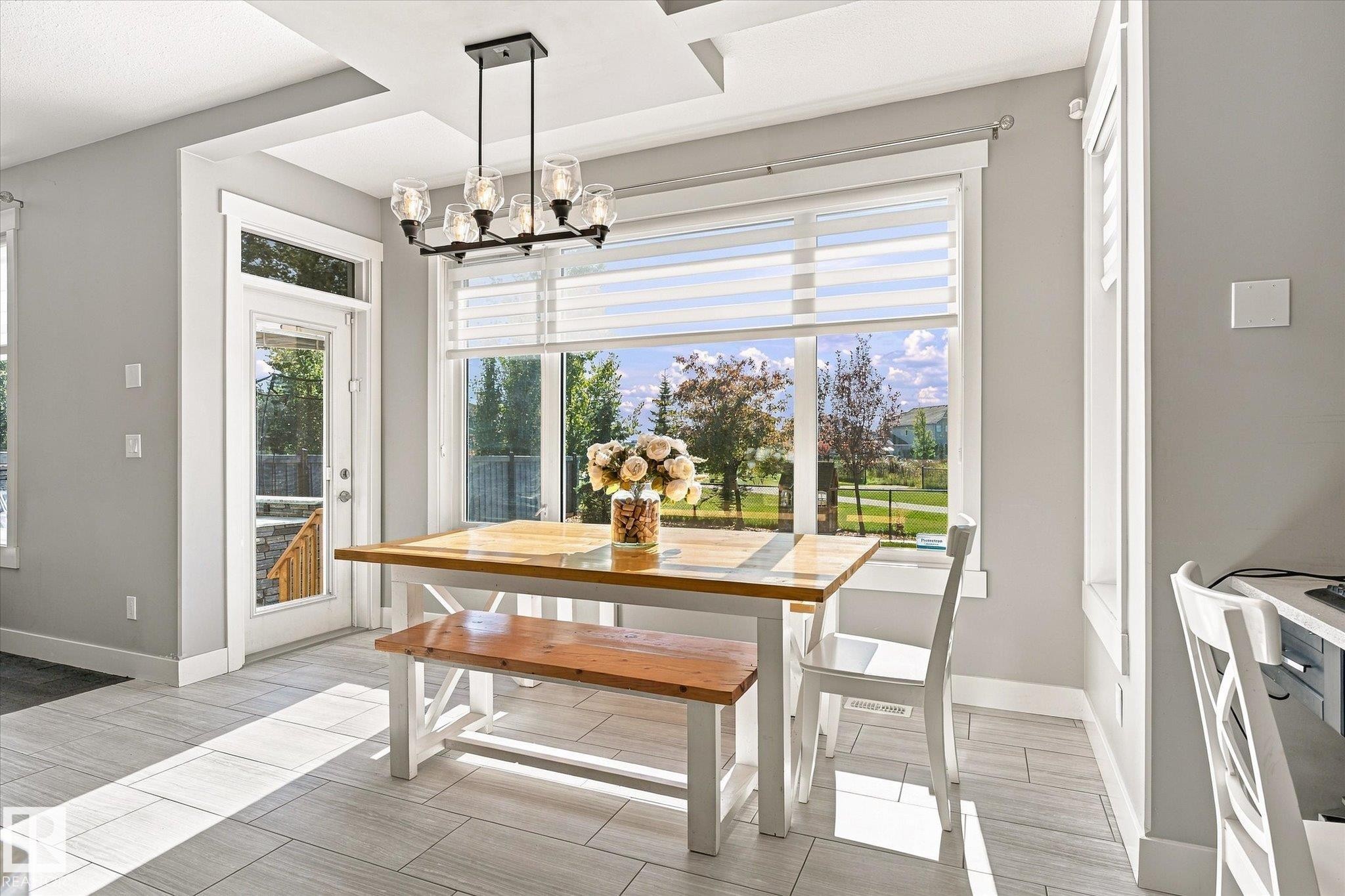 Recessed ceiling details, large picture window with blinds, modern multi-bulb chandelier, and tiled flooring - 2011 Genesis Lane, Stony Plain, AB