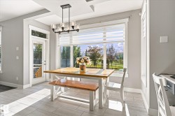 Recessed ceiling details, large picture window with blinds, modern multi-bulb chandelier, and tiled flooring - 
