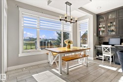 Porcelain tile flooring, large windows, tray ceiling, dark wood-finish cabinetry, and built-in desk area - 