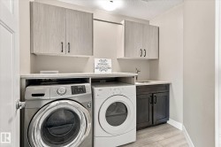 Laundry area featuring upper cabinetry, a utility sink, and a countertop - 