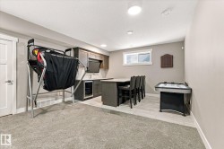 Built-in wet bar with dark cabinetry, integrated beverage refrigerator, and countertop seating - 