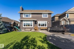 Two-story exterior with dark siding and white trim - 