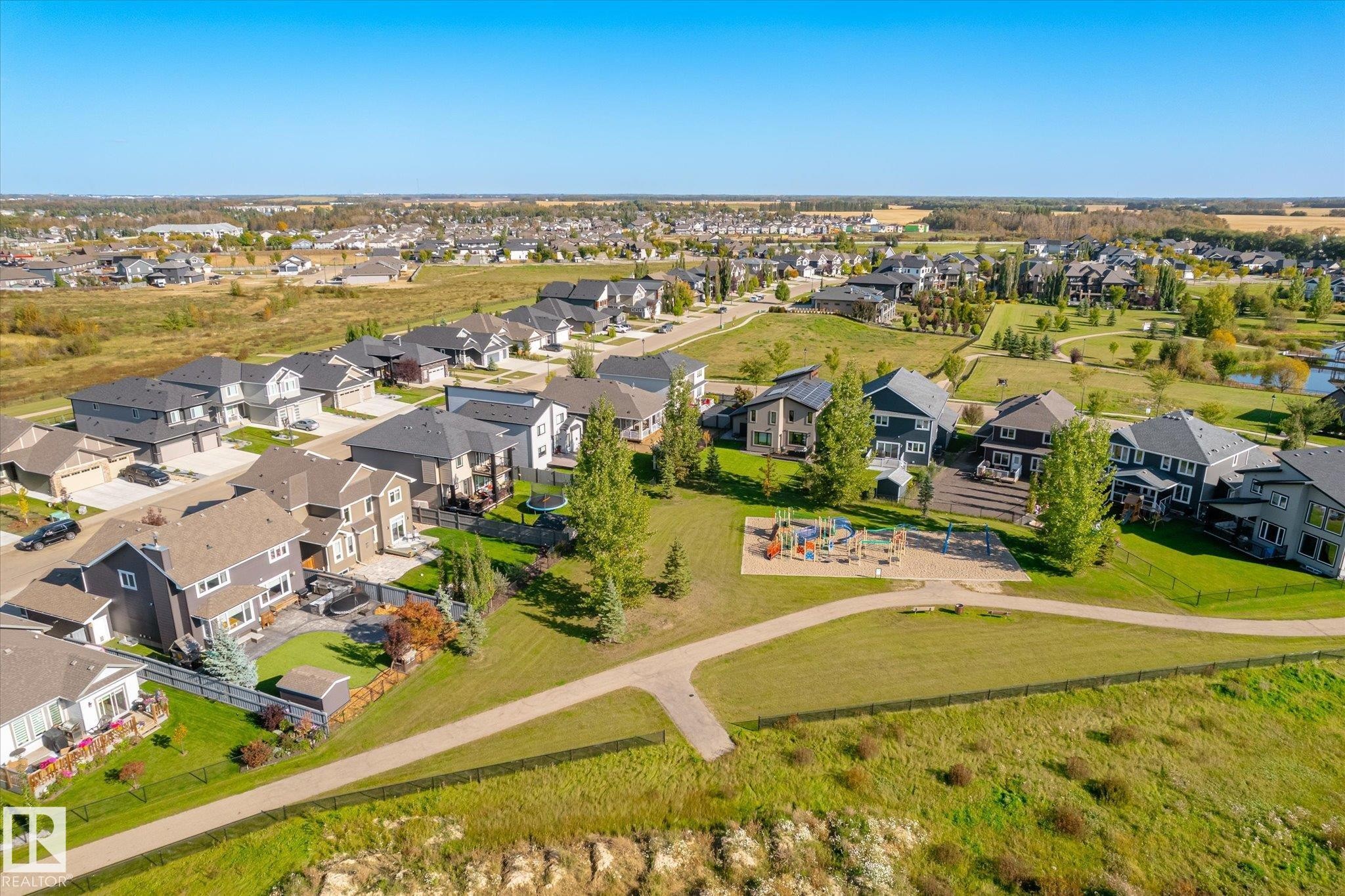 Neighborhood featuring a community park with playground equipment and paved walking paths - 2011 Genesis Lane, Stony Plain, AB