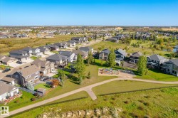 Neighborhood featuring a community park with playground equipment and paved walking paths - 