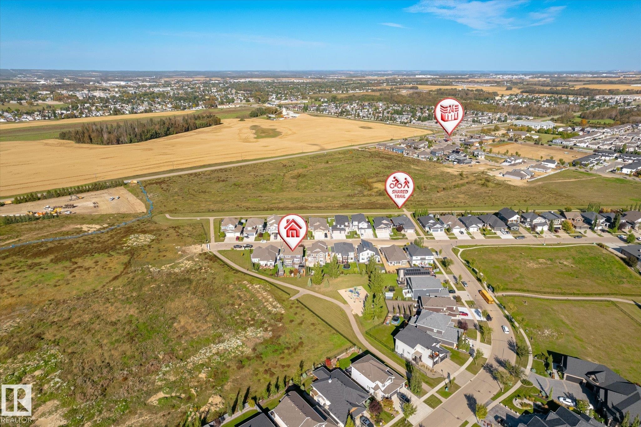 Aerial perspective of a developed neighborhood with surrounding open fields and residential areas - 2011 Genesis Lane, Stony Plain, AB