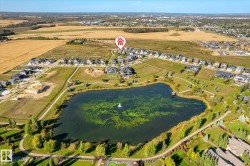 Manicured grounds with a water feature, paved walking paths, and surrounding mature landscaping - 