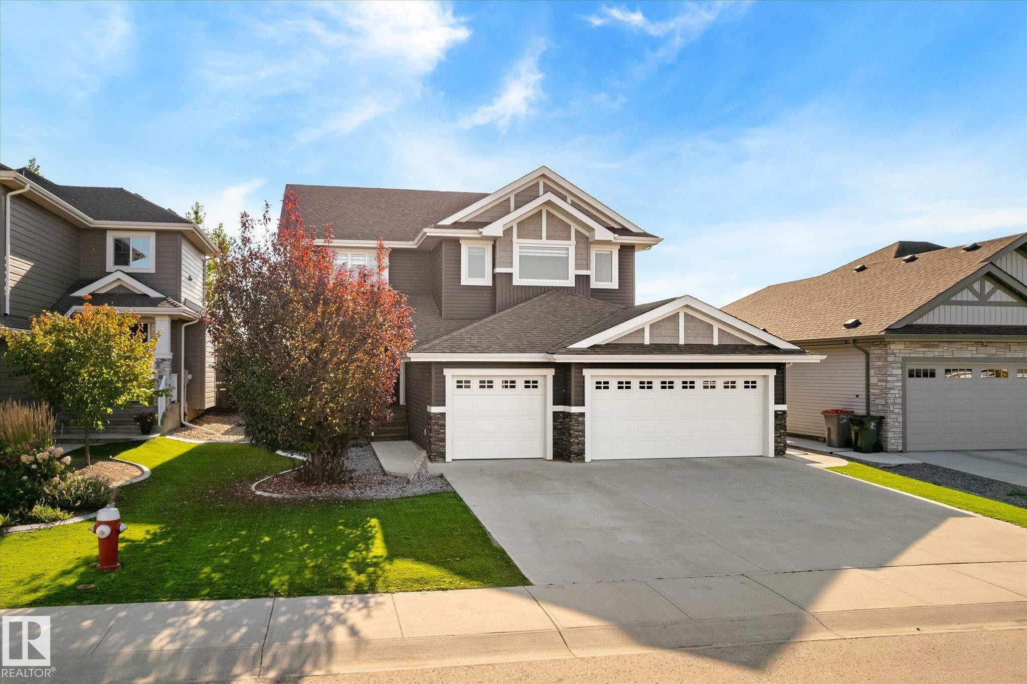 Two-story residence featuring a dark grey exterior with white trim accents and a black roof - 2011 Genesis Lane, Stony Plain, AB