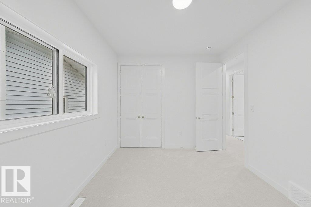 Carpeted room featuring a white interior, white trim, and a horizontal sliding window - 9216 91 Street Nw, Edmonton, AB - Indoor Photo Showing Other Room