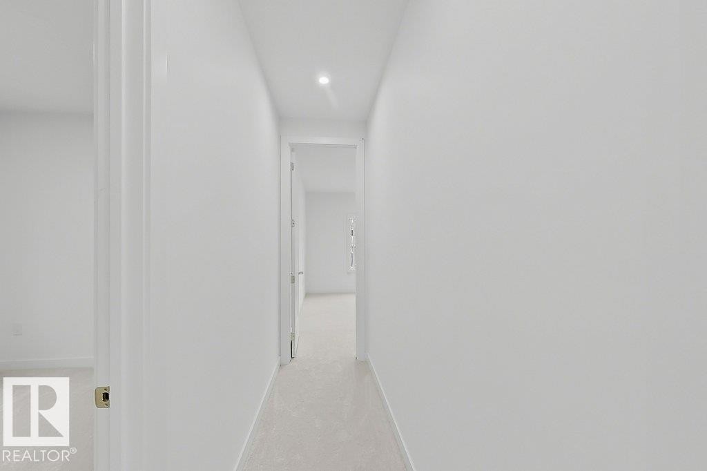 Central hallway with recessed lighting and light-toned wall-to-wall carpeting - 9216 91 Street Nw, Edmonton, AB - Indoor With Storage