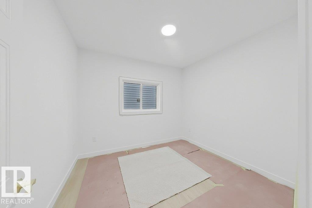 Bright interior space featuring a window with horizontal blinds, overhead lighting, and white baseboards - 9216 91 Street Nw, Edmonton, AB - Indoor Photo Showing Bathroom