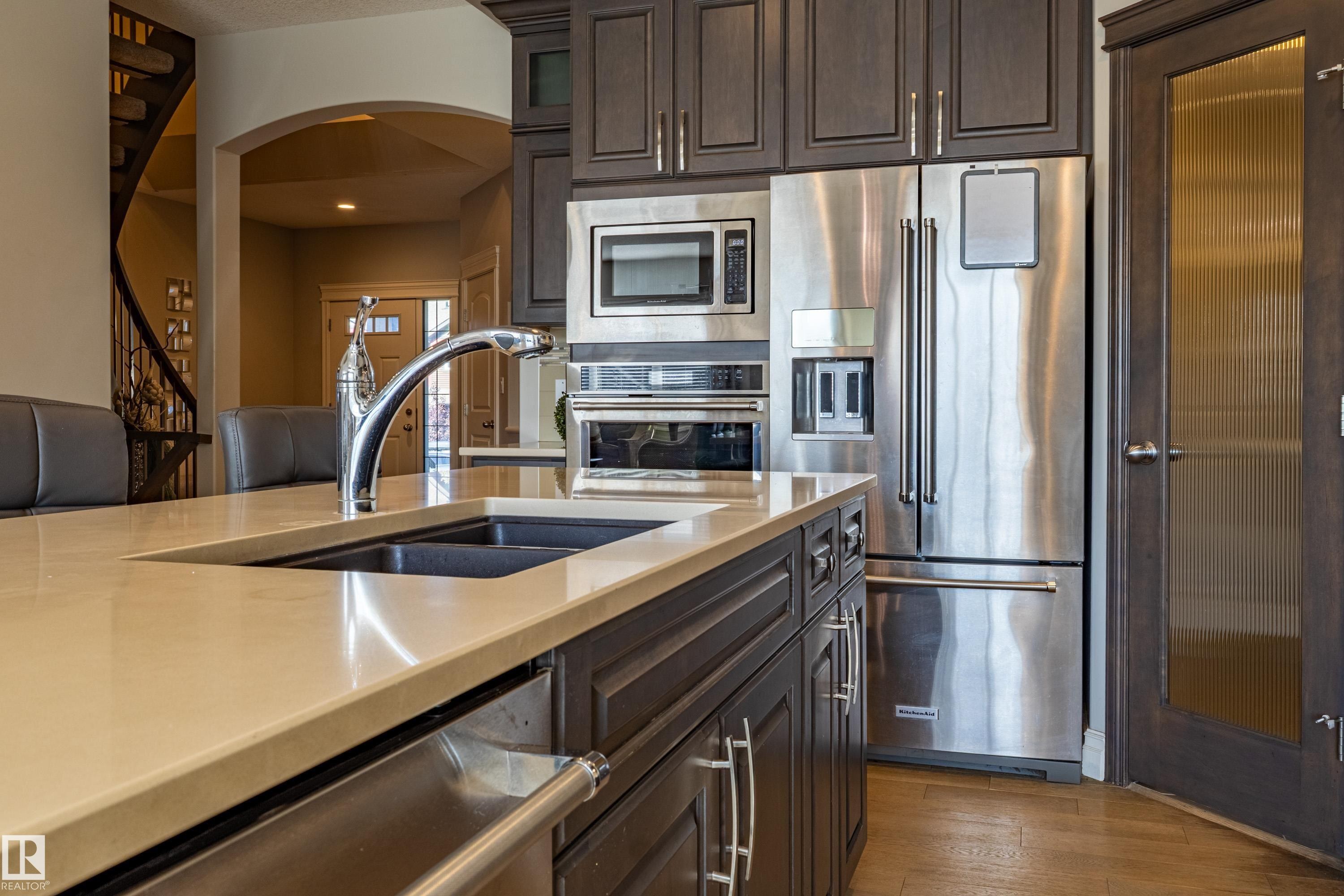 Kitchen island with a built-in double sink and chrome faucet - 233 Hawks Ridge Boulevard Nw, Edmonton, AB
