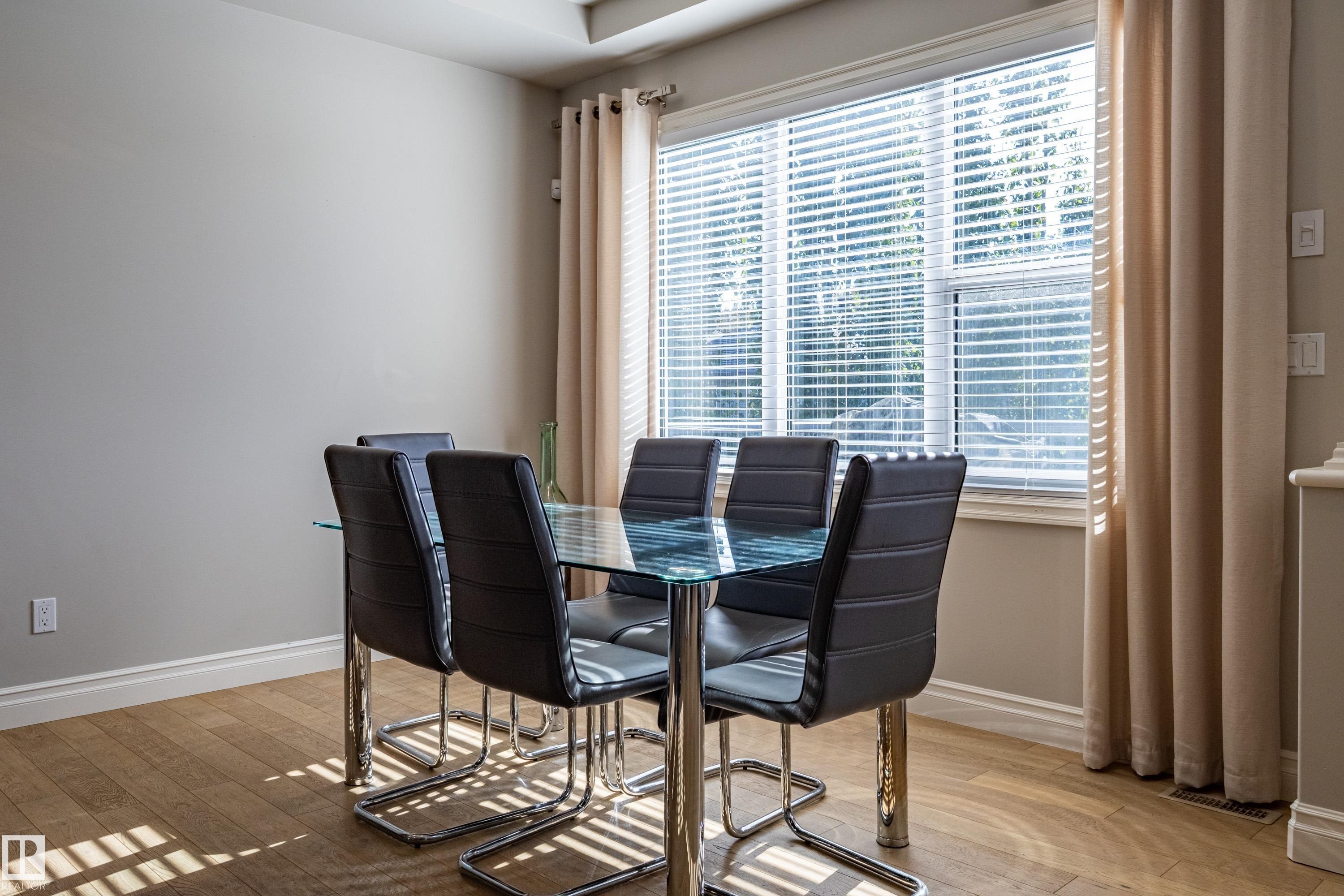 Wood-finish flooring, neutral wall tones, window with horizontal blinds, and a ceiling-mounted light fixture - 233 Hawks Ridge Boulevard Nw, Edmonton, AB