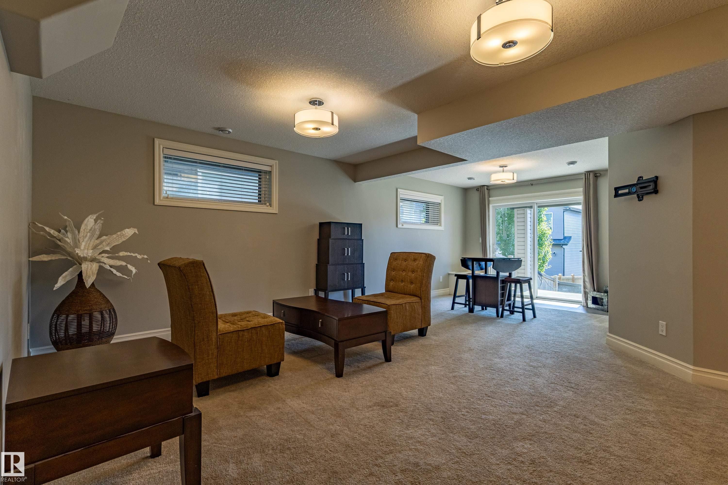 Plush carpeting, recessed lighting, and a sliding glass door - 233 Hawks Ridge Boulevard Nw, Edmonton, AB