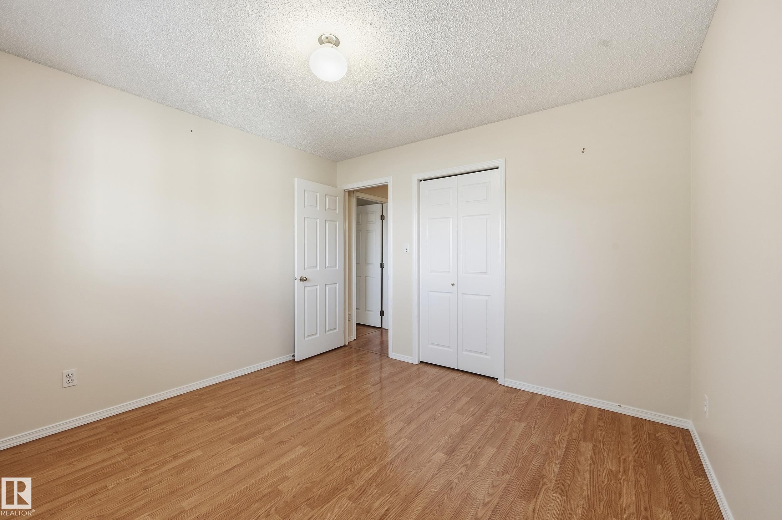 Wood-finish flooring with neutral wall tones and a white ceiling - 11102 11A Avenue Nw, Edmonton, AB