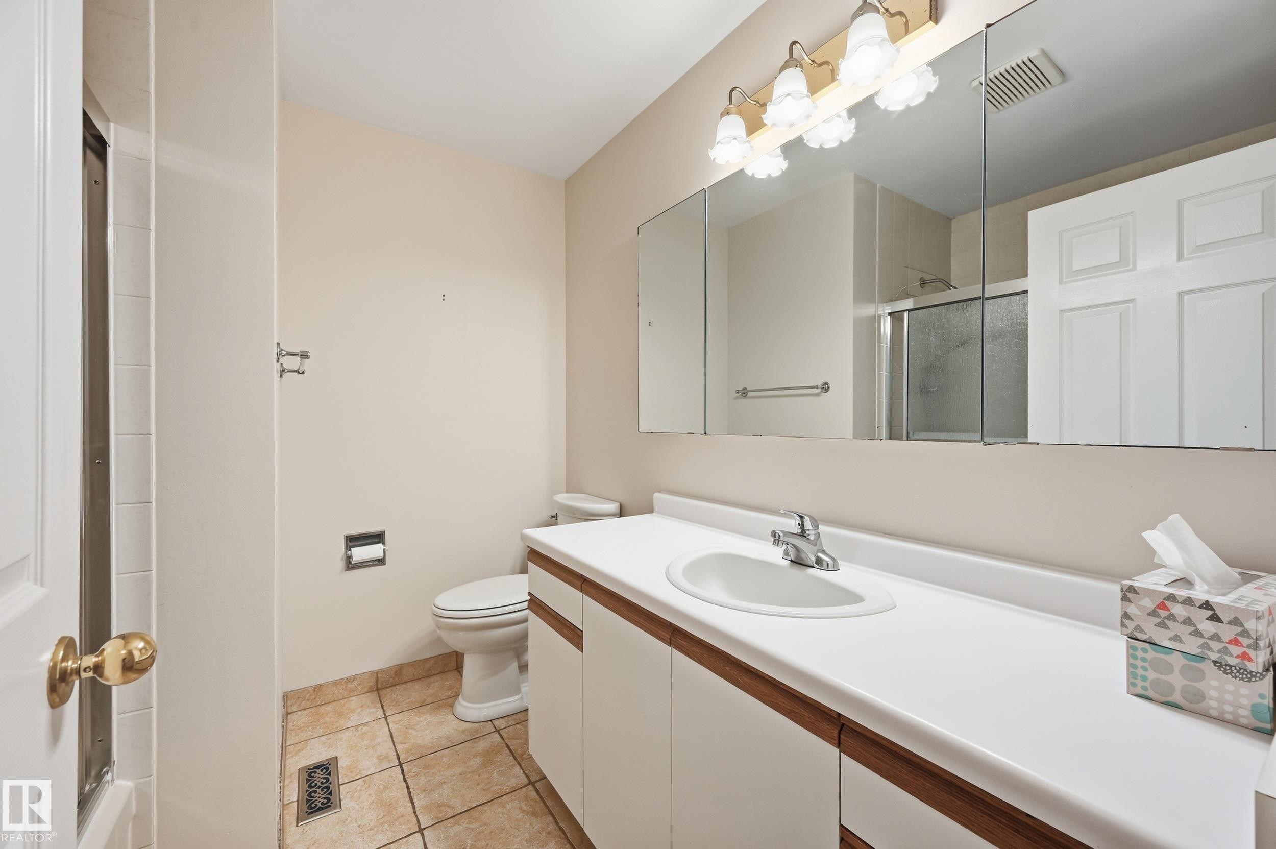 Vanity with an integrated sink, polished chrome faucet, and wood-finish cabinetry - 11102 11A Avenue Nw, Edmonton, AB