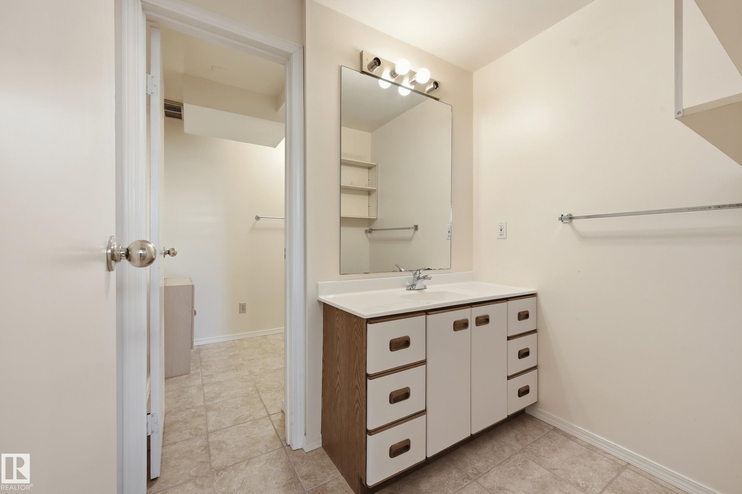White vanity with integrated sink, chrome faucet, and mirrored cabinet - 11102 11A Avenue Nw, Edmonton, AB