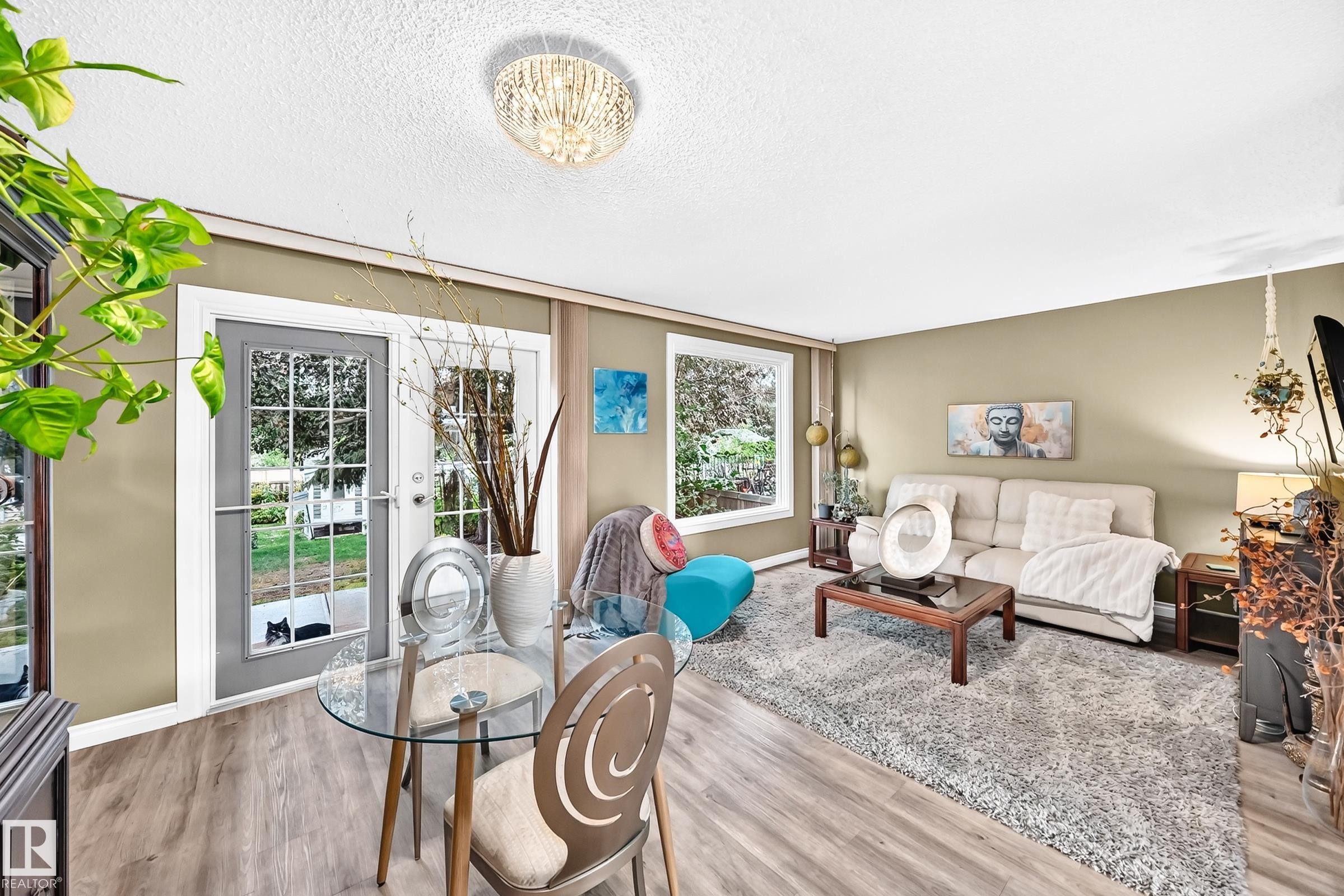 Light-toned walls with wood-finish flooring, featuring a crystal-adorned ceiling light and transom windows - 5620 93A Avenue Nw, Edmonton, AB