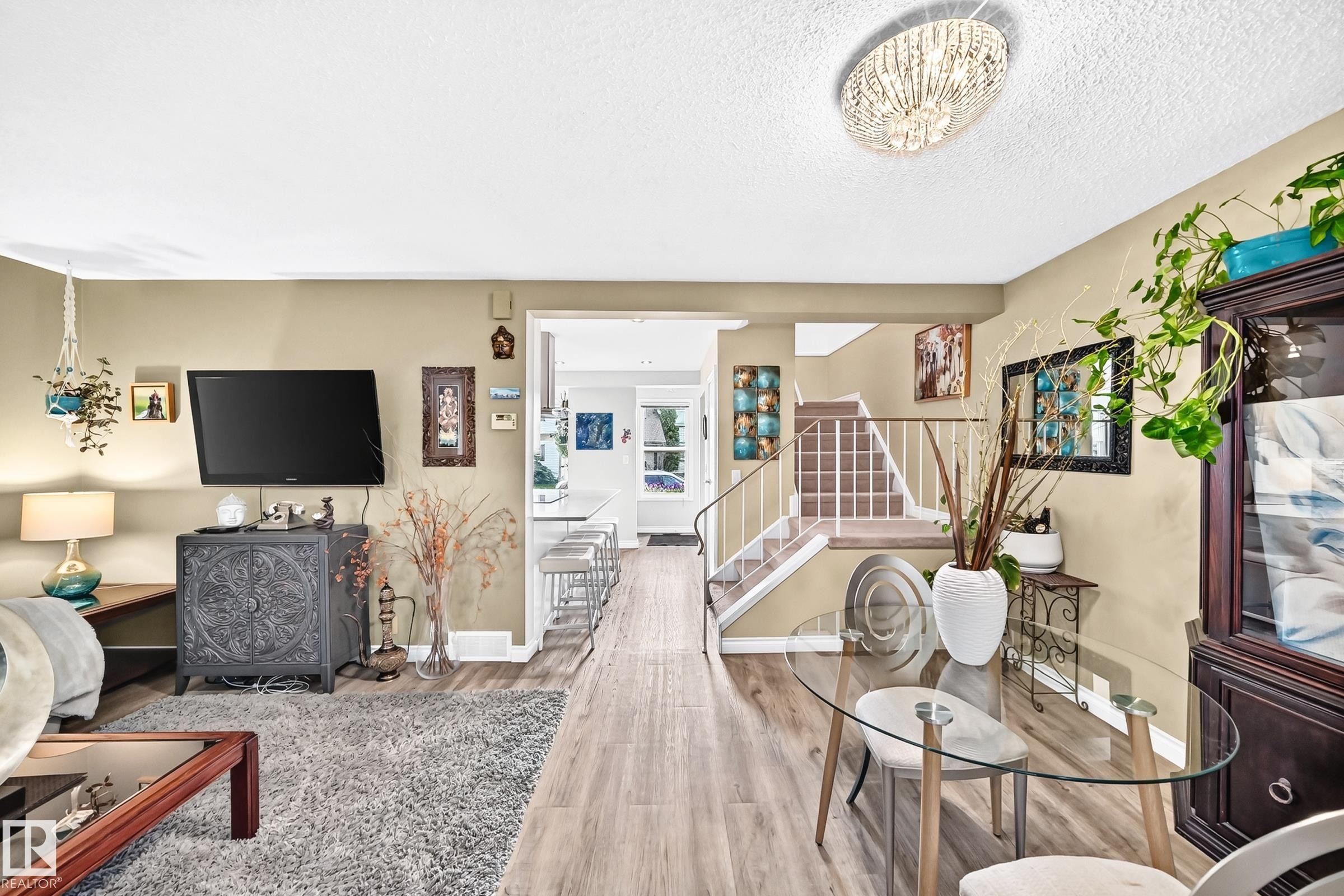 Wood-finish flooring throughout, with a decorative ceiling light fixture - 5620 93A Avenue Nw, Edmonton, AB