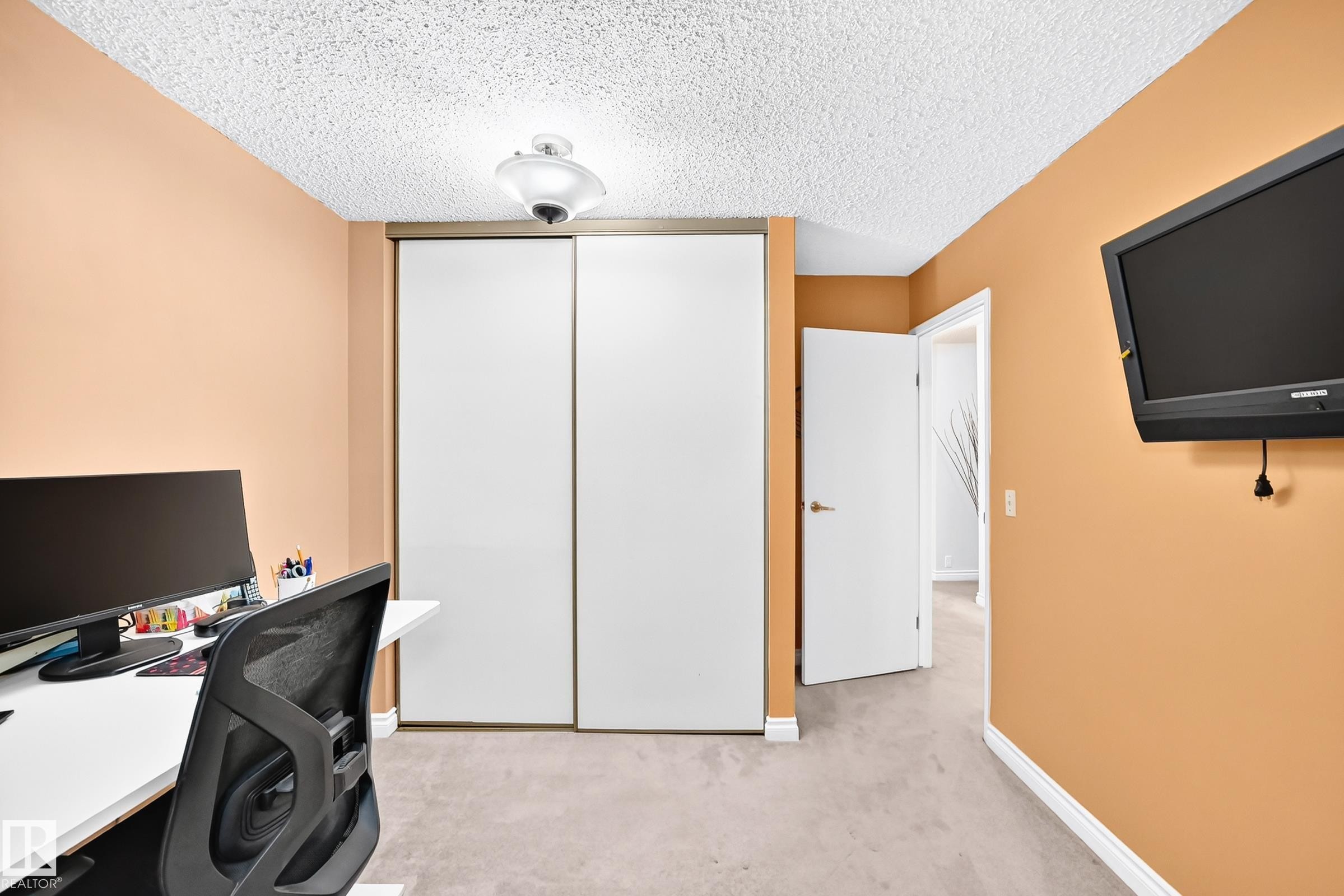 Recessed sliding panel closet doors, neutral carpet flooring, and a flush mount ceiling fixture - 5620 93A Avenue Nw, Edmonton, AB