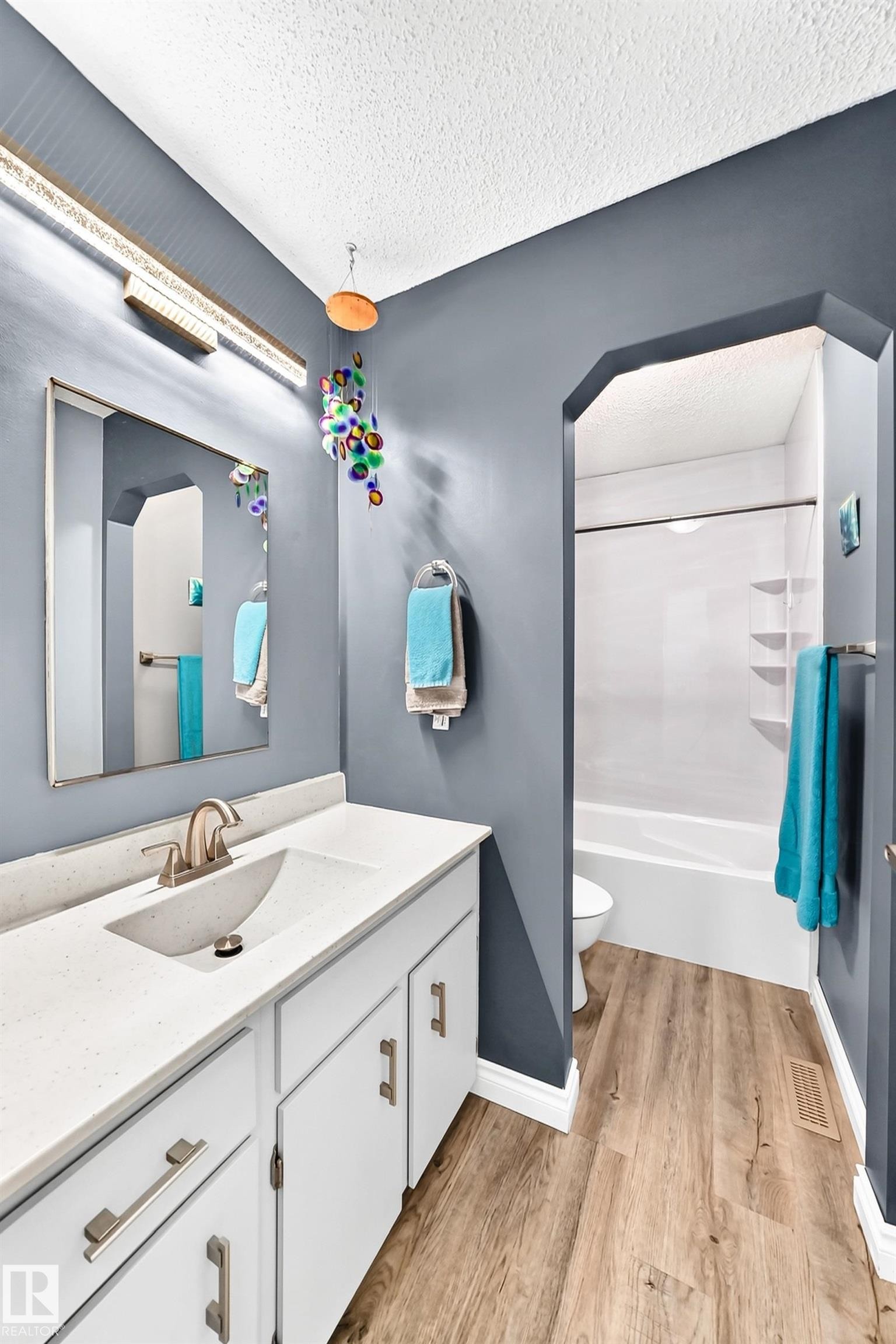 White vanity with brushed nickel hardware, integrated sink, and light-colored countertop - 5620 93A Avenue Nw, Edmonton, AB