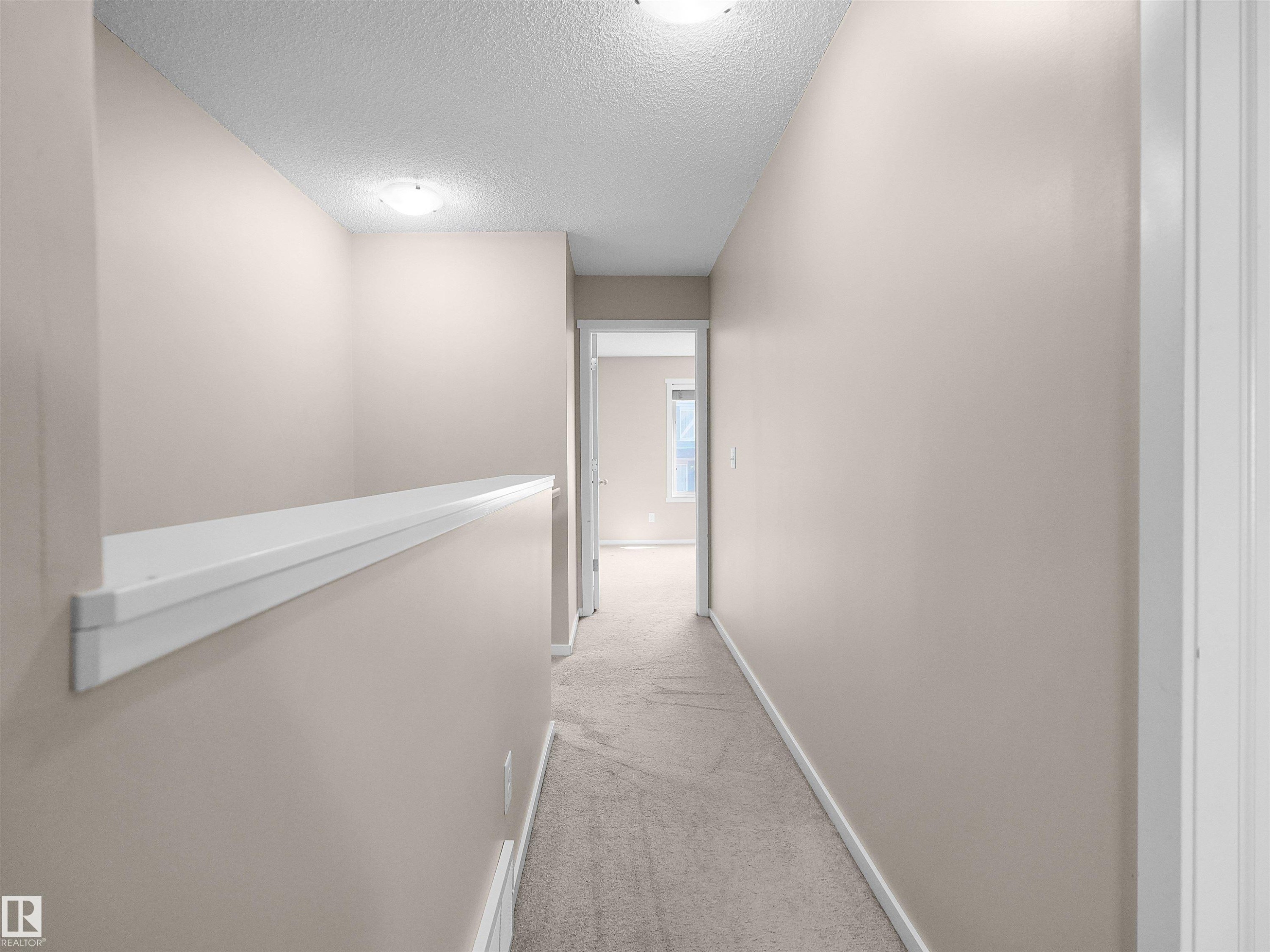 Carpeted hallway with neutral wall paint and overhead lighting - #162 603 Watt Bv Sw, Edmonton, AB