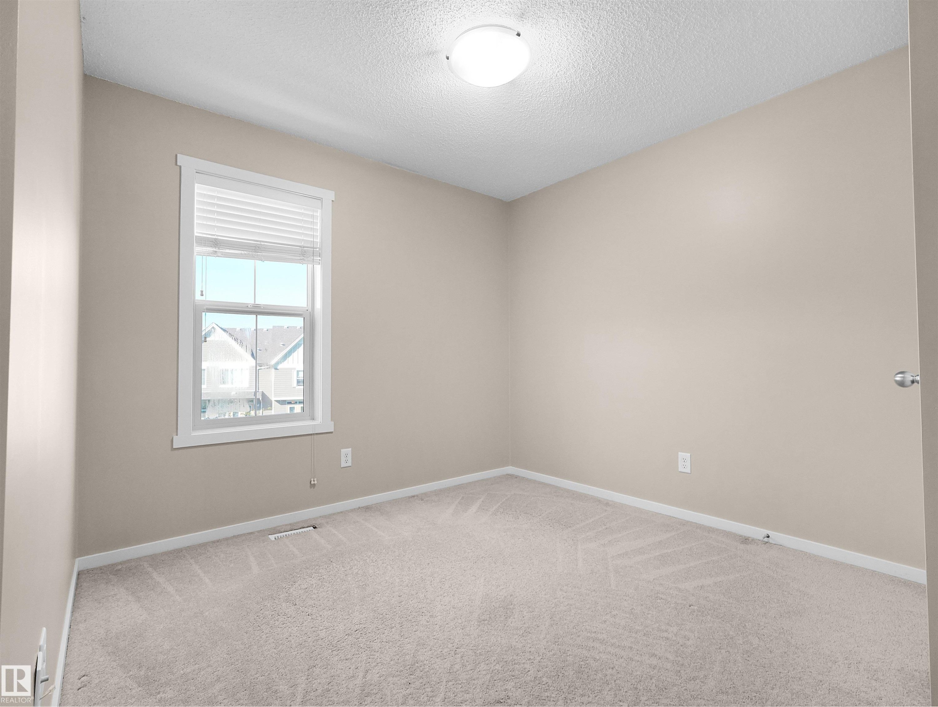 Neutral-toned walls, plush carpeting, and a window with white blinds - #162 603 Watt Bv Sw, Edmonton, AB