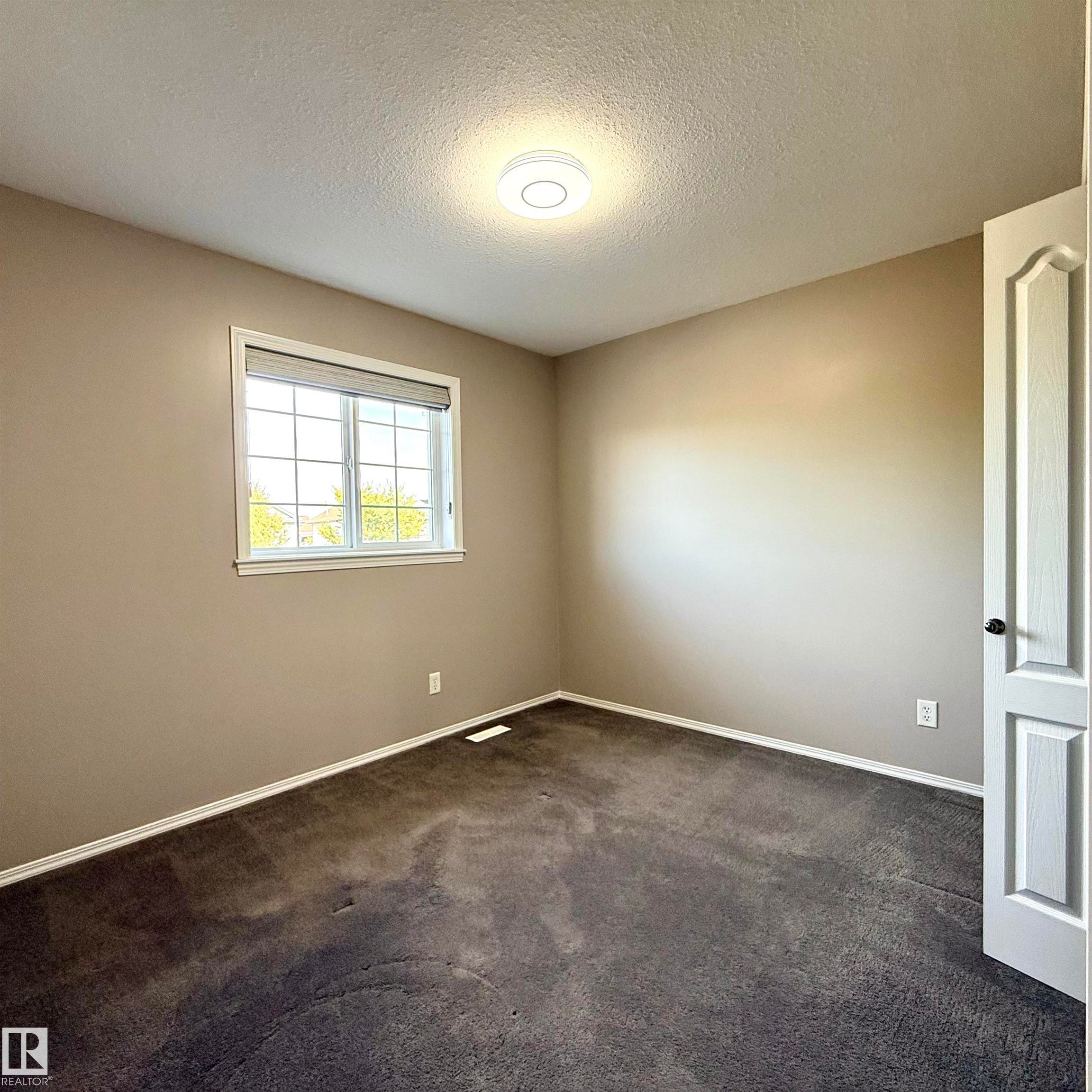 Neutral wall tones with dark carpeting - 910 Oakland Boulevard, Devon, AB
