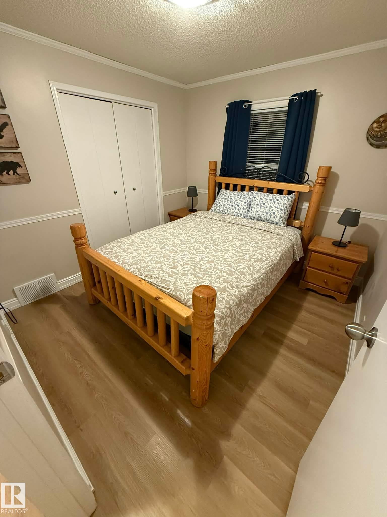 Wood-finish flooring, bi-fold closet doors, window with horizontal blinds, and a flush mount ceiling light - 10649 125 Street Nw, Edmonton, AB