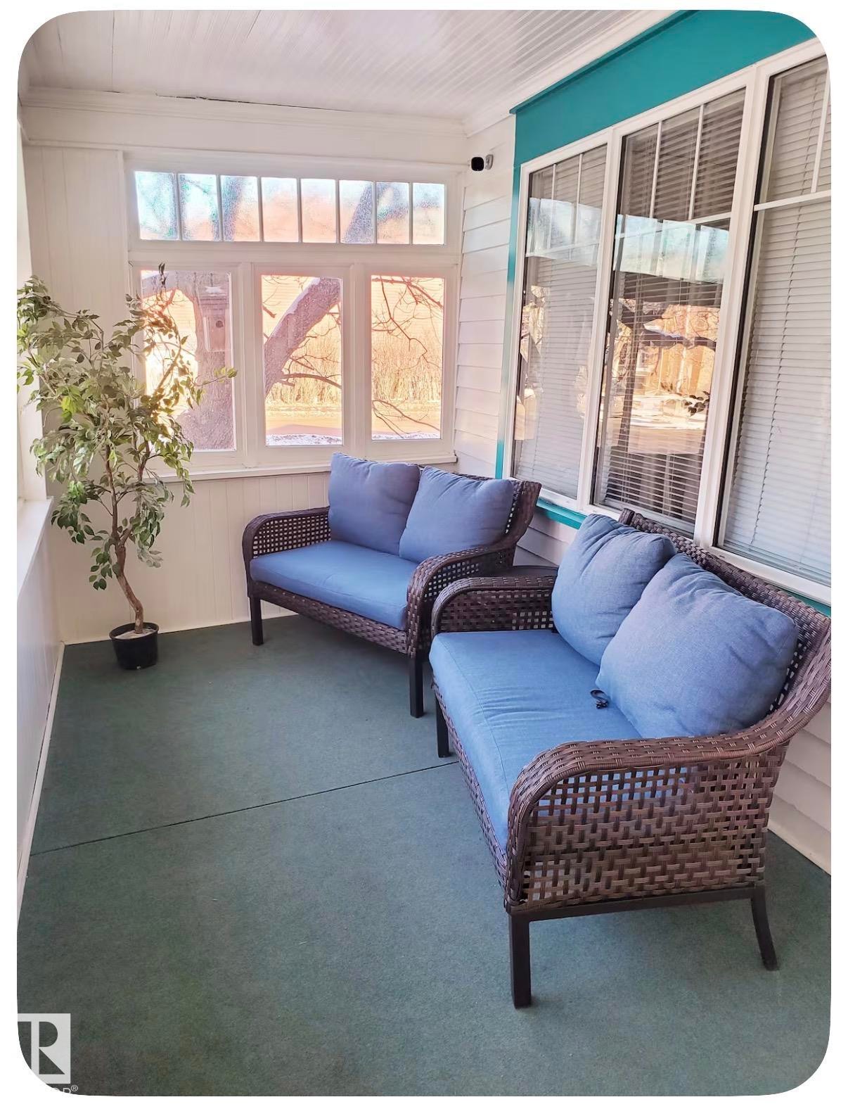 Enclosed porch featuring multiple windows, a white paneled ceiling, and green flooring - 10649 125 Street Nw, Edmonton, AB