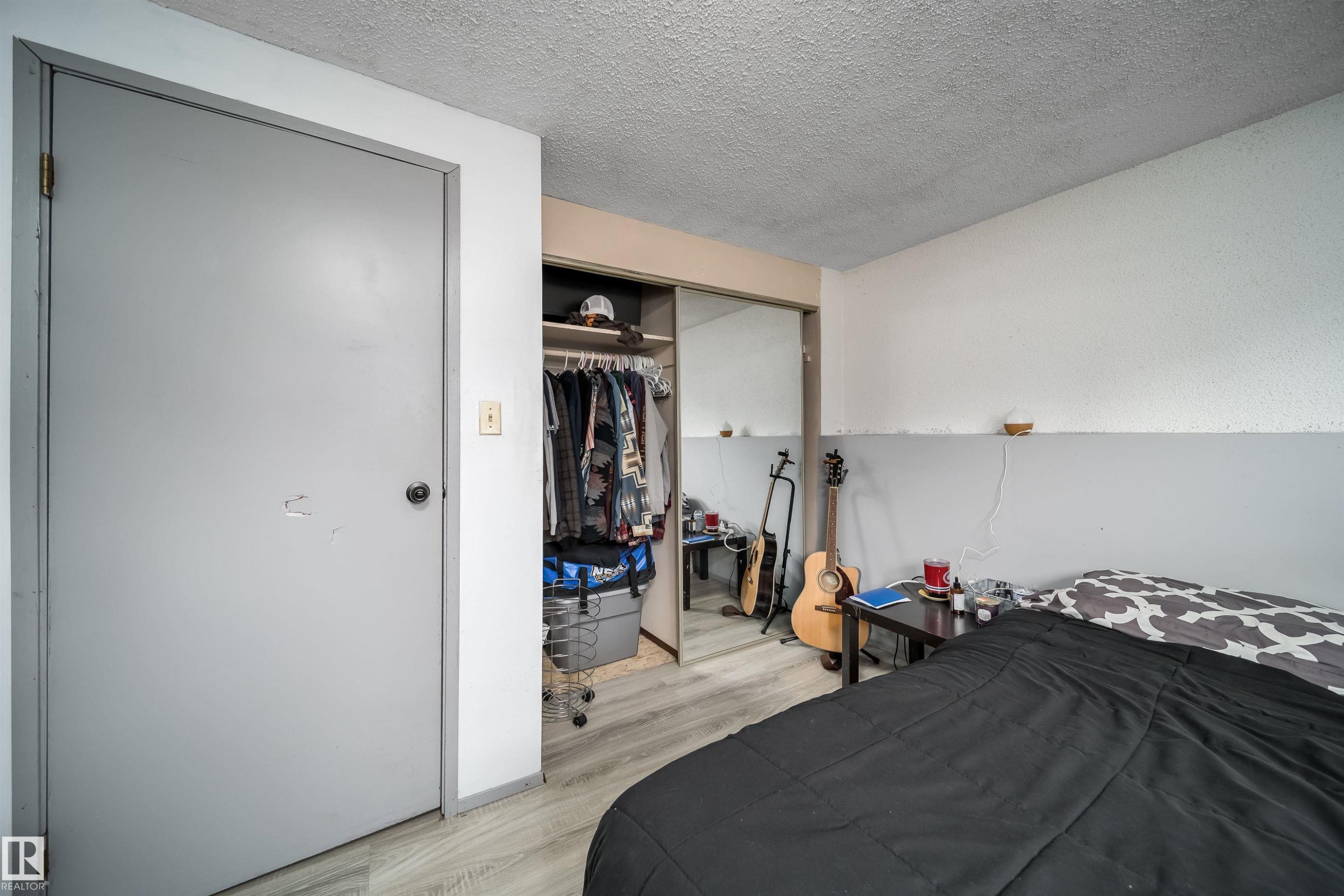 Wood-finish flooring with a mirrored closet door - 4104 44 Street, Stony Plain, AB