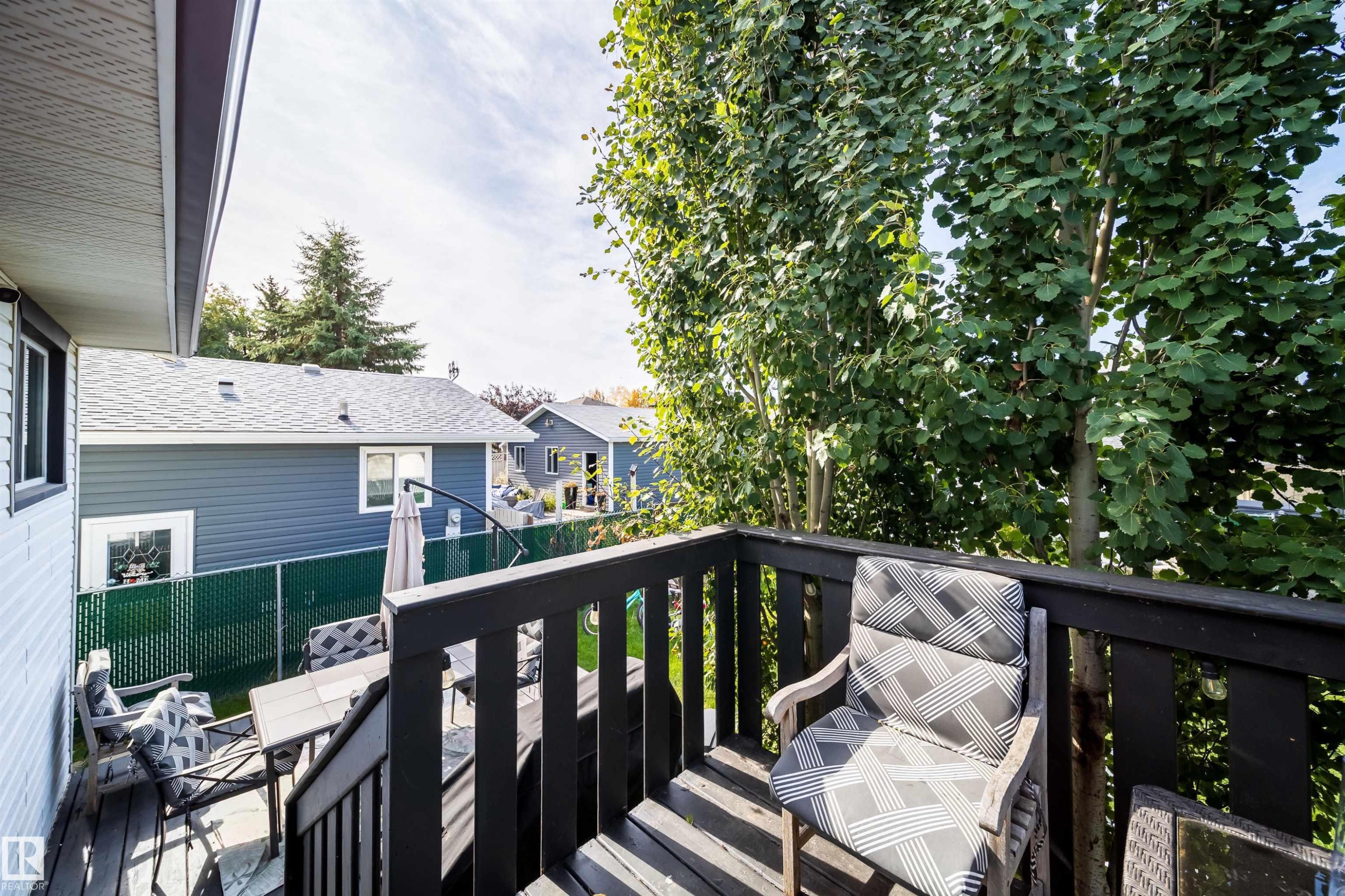Two-tier wood-finish deck with dark railing and integrated steps - 4104 44 Street, Stony Plain, AB